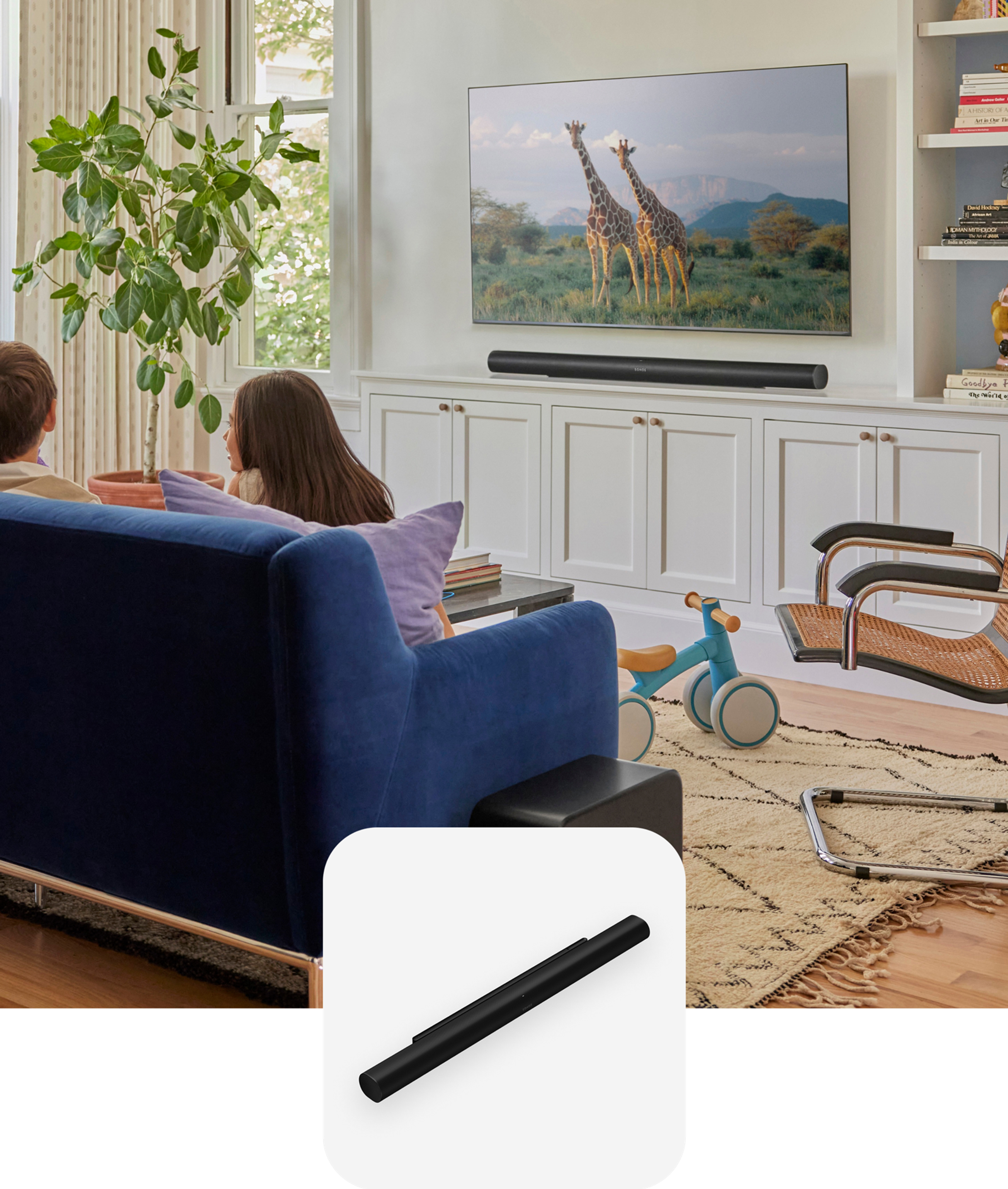 Kids sitting on a blue couch in the living room with black Sonos Sub 4 and Arc Ultra and a black Arc Ultra product tile overlay