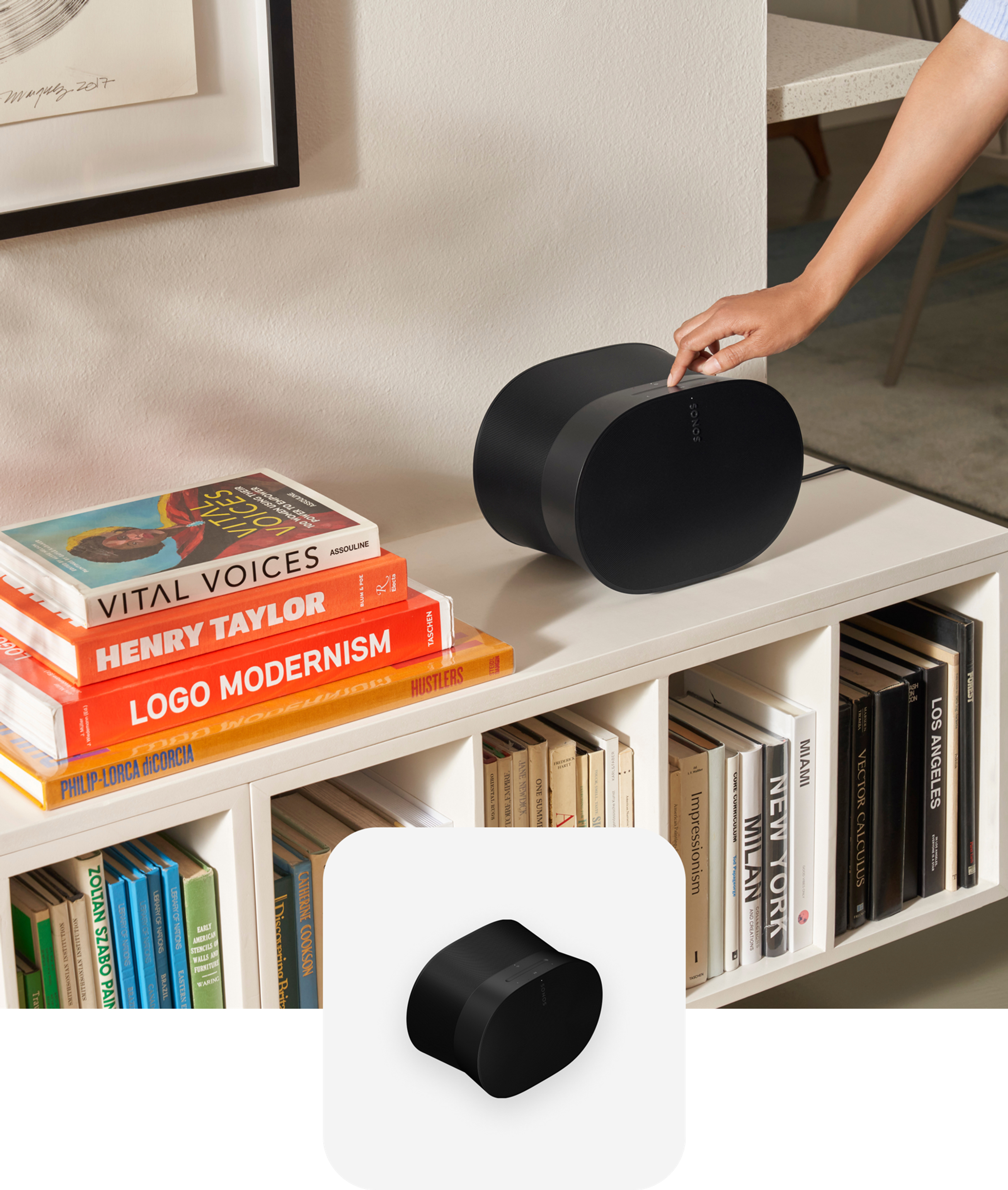 User engaging with the touch controls on a black Era 300 speaker on a white media console