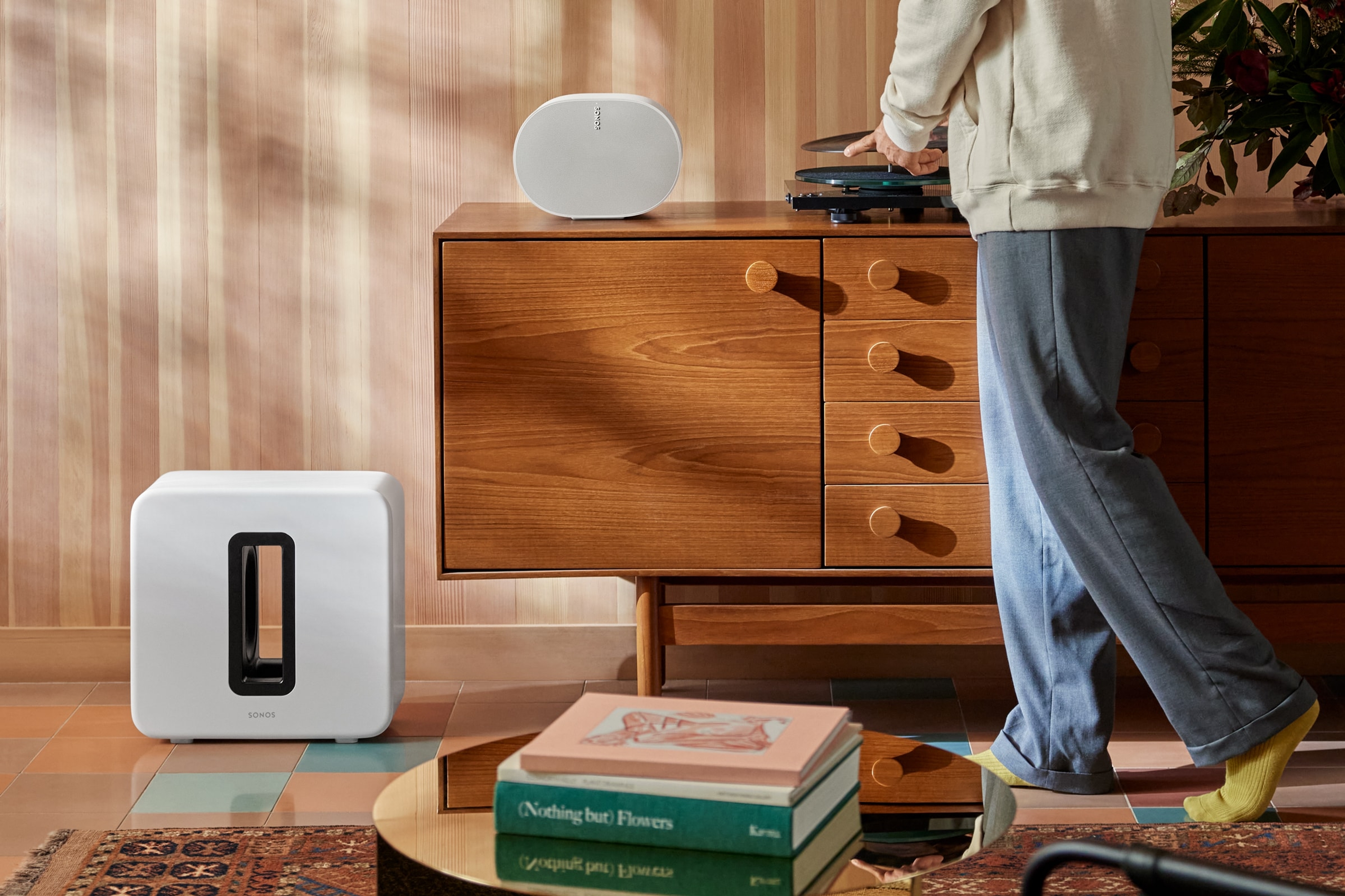 A white Sonos Sub 4 and a white Sonos Era 300 on top of a console table