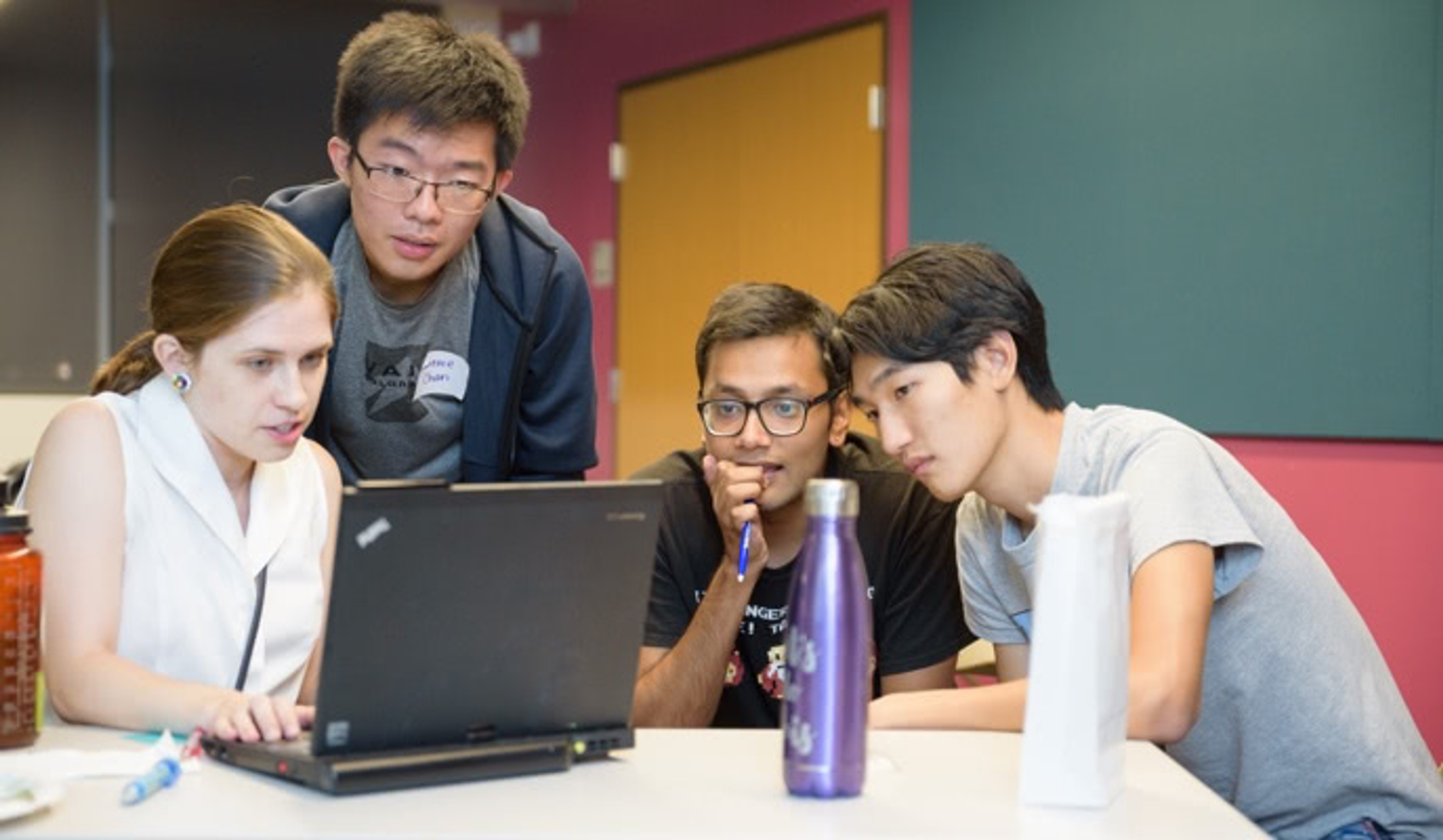 Group of students looking at a laptop