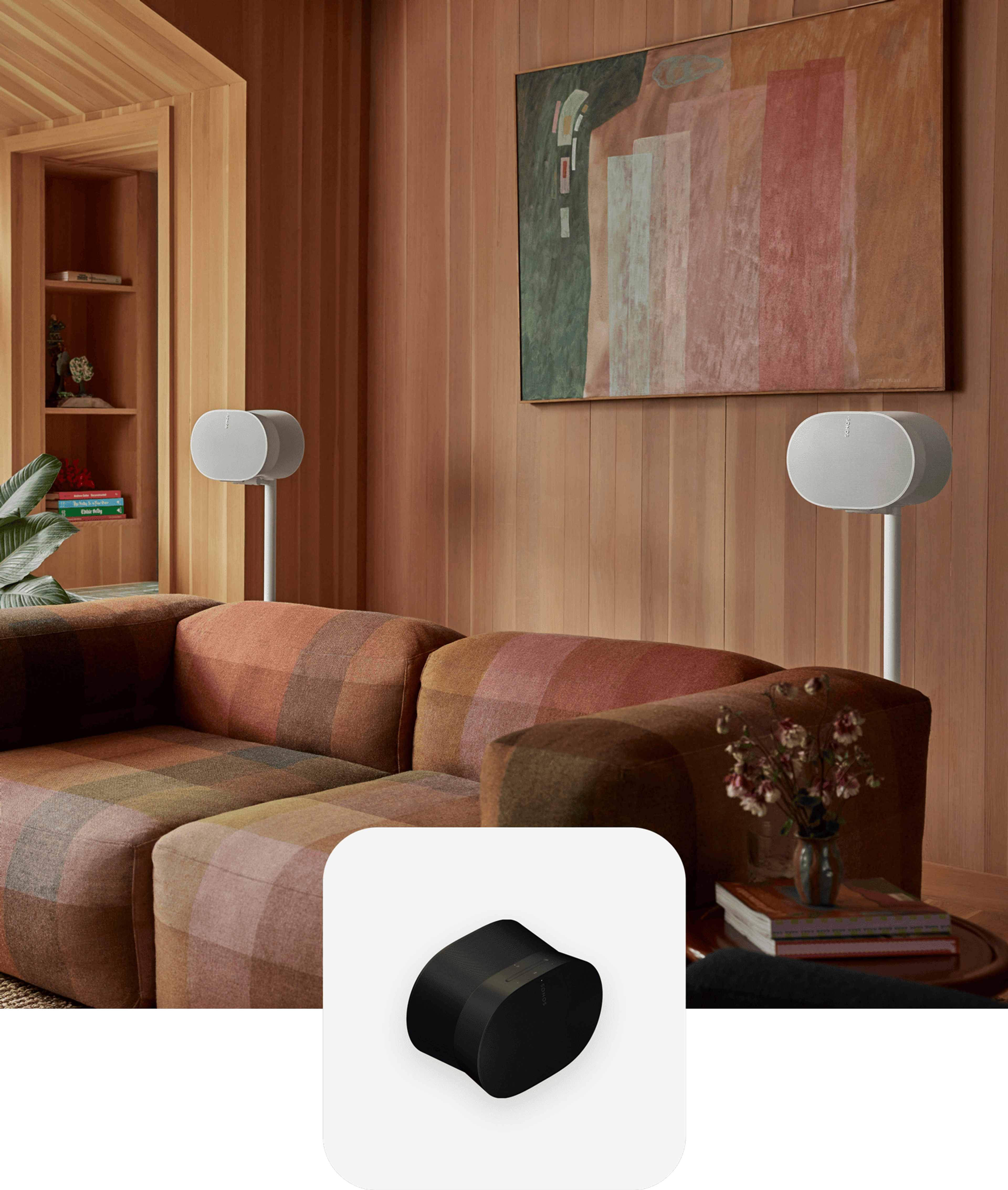 A pair of white Era 300 speakers on stands set up behind a couch for surround sound