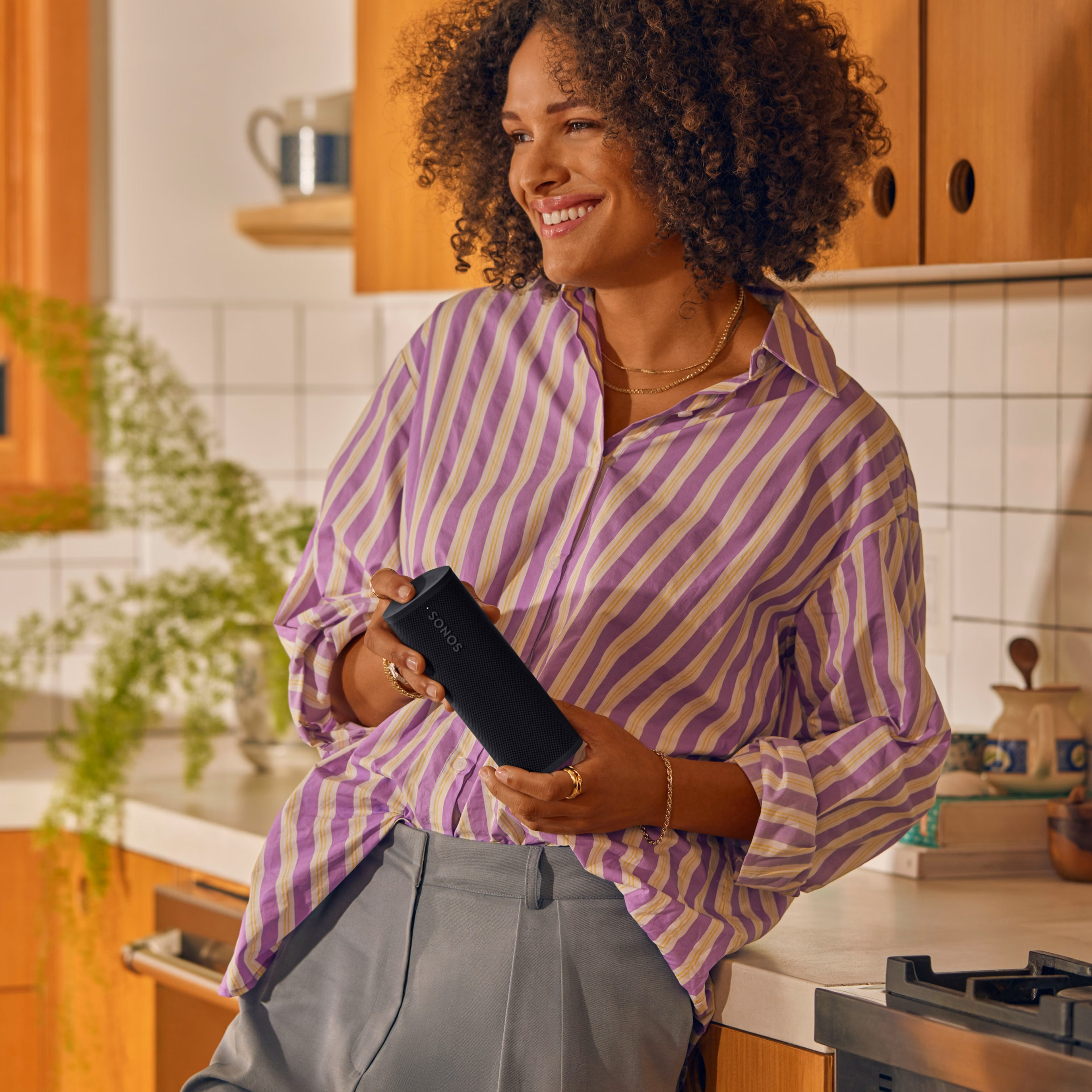 Person holding a Sonos Roam 2 in Black in the kitchen