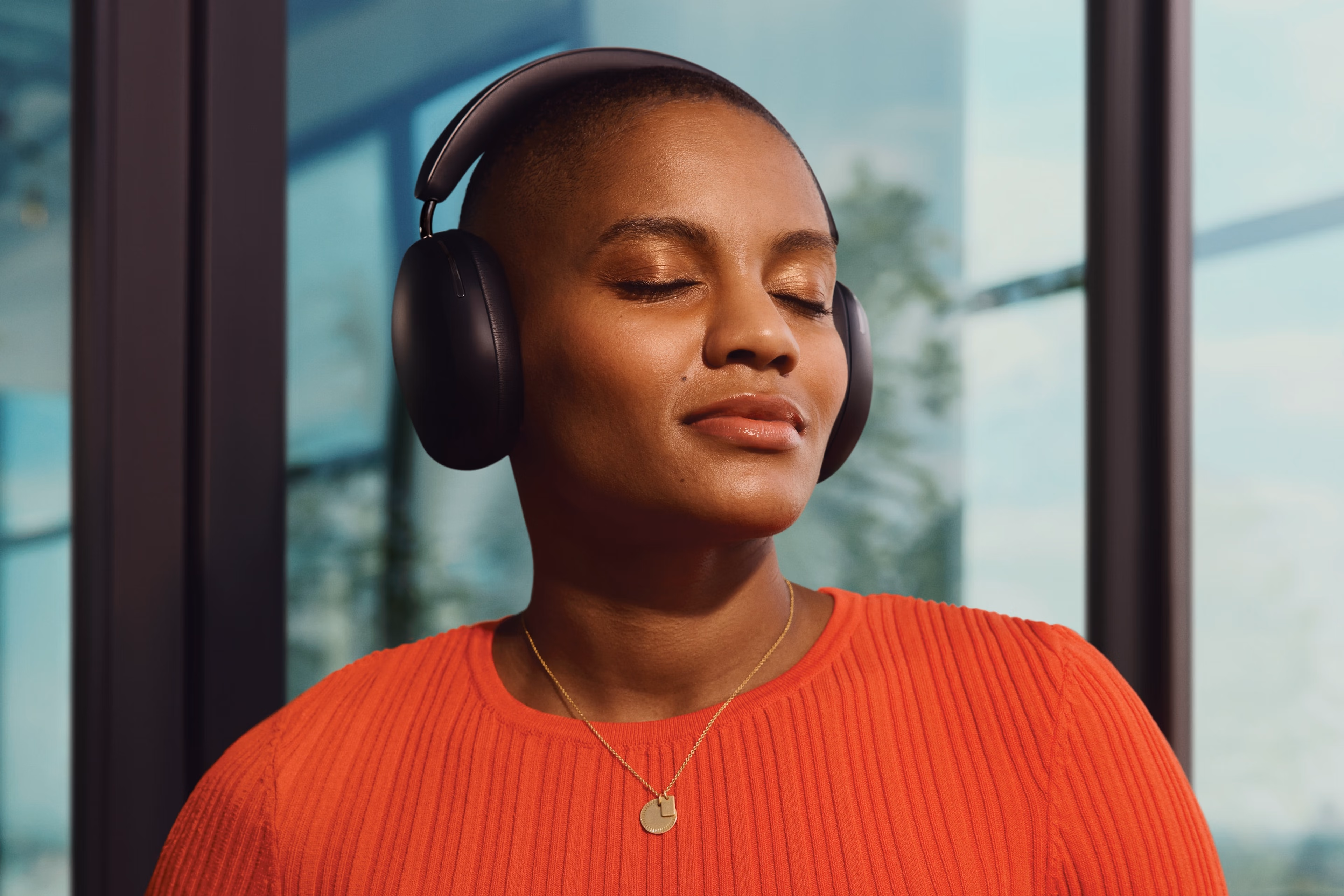 Person listening to music on black Sonos Ace headphones with eyes closed
