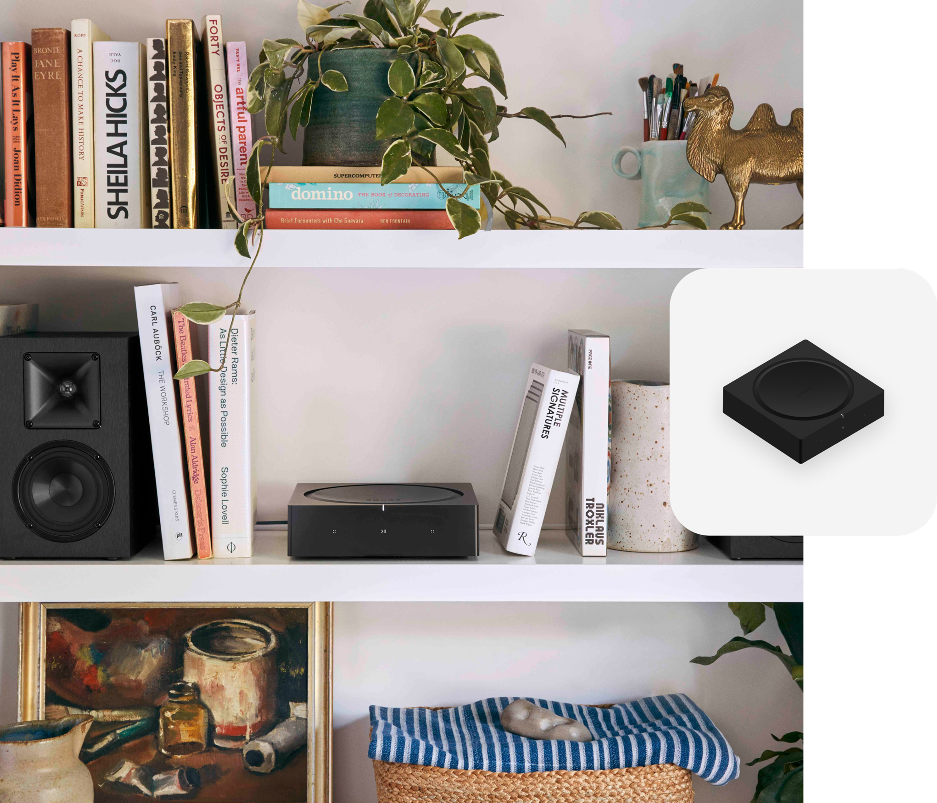 Sonos Amp on a white bookshelf between a pair of bookshelf speakers