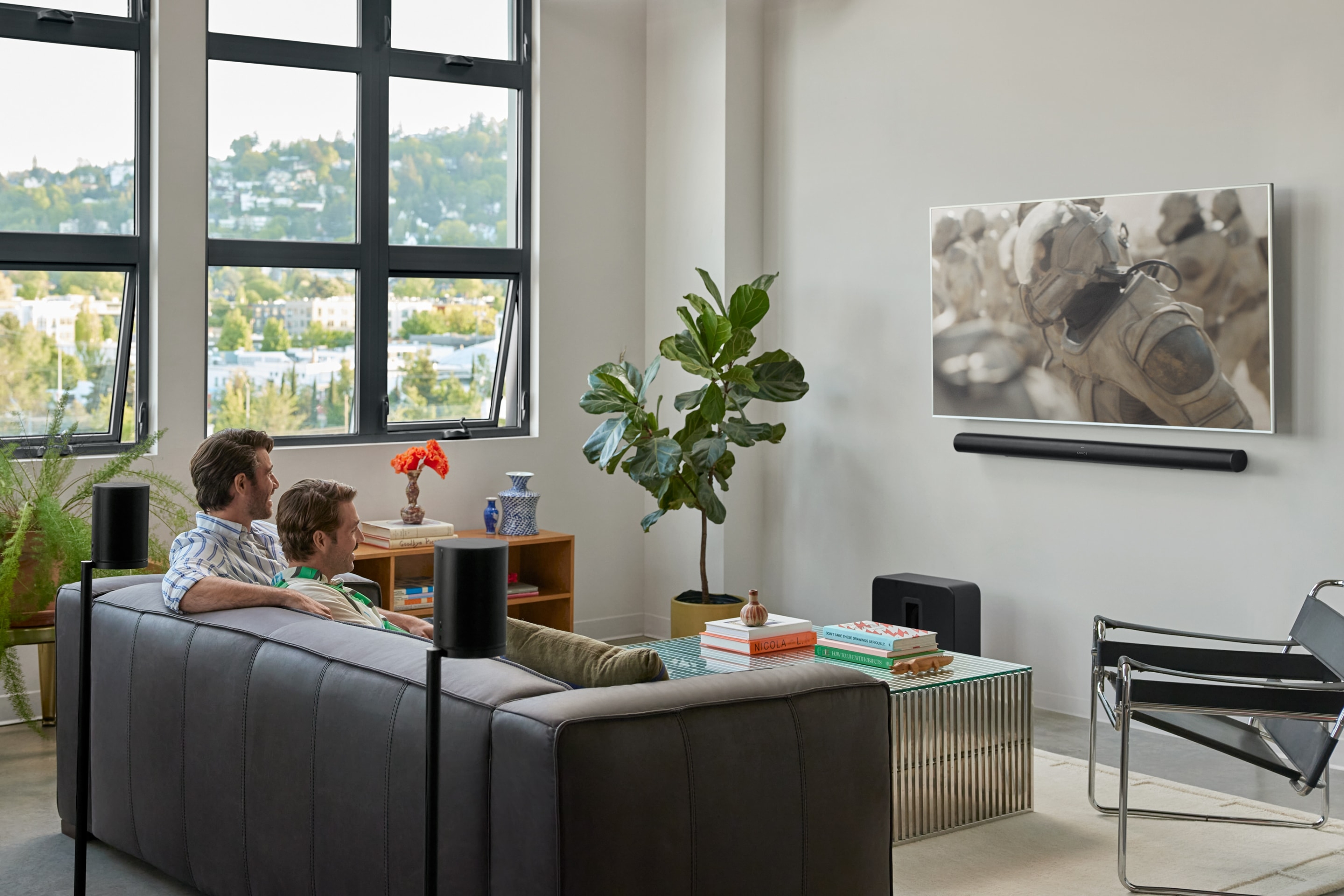 Two people sitting on the couch watching Dune 2 with a Arc Ultra home theatre system