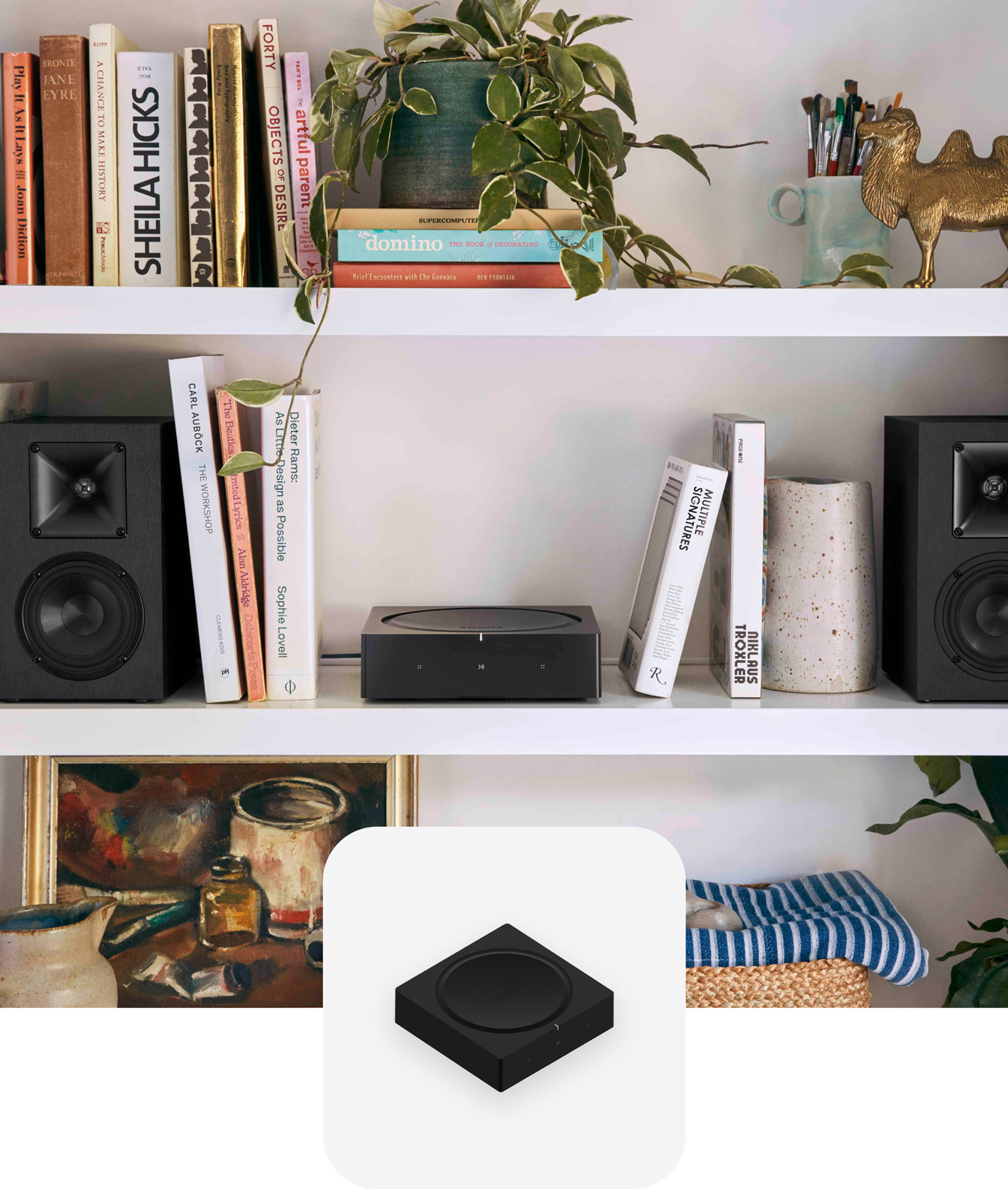 Sonos Amp on a white bookshelf between a pair of bookshelf speakers