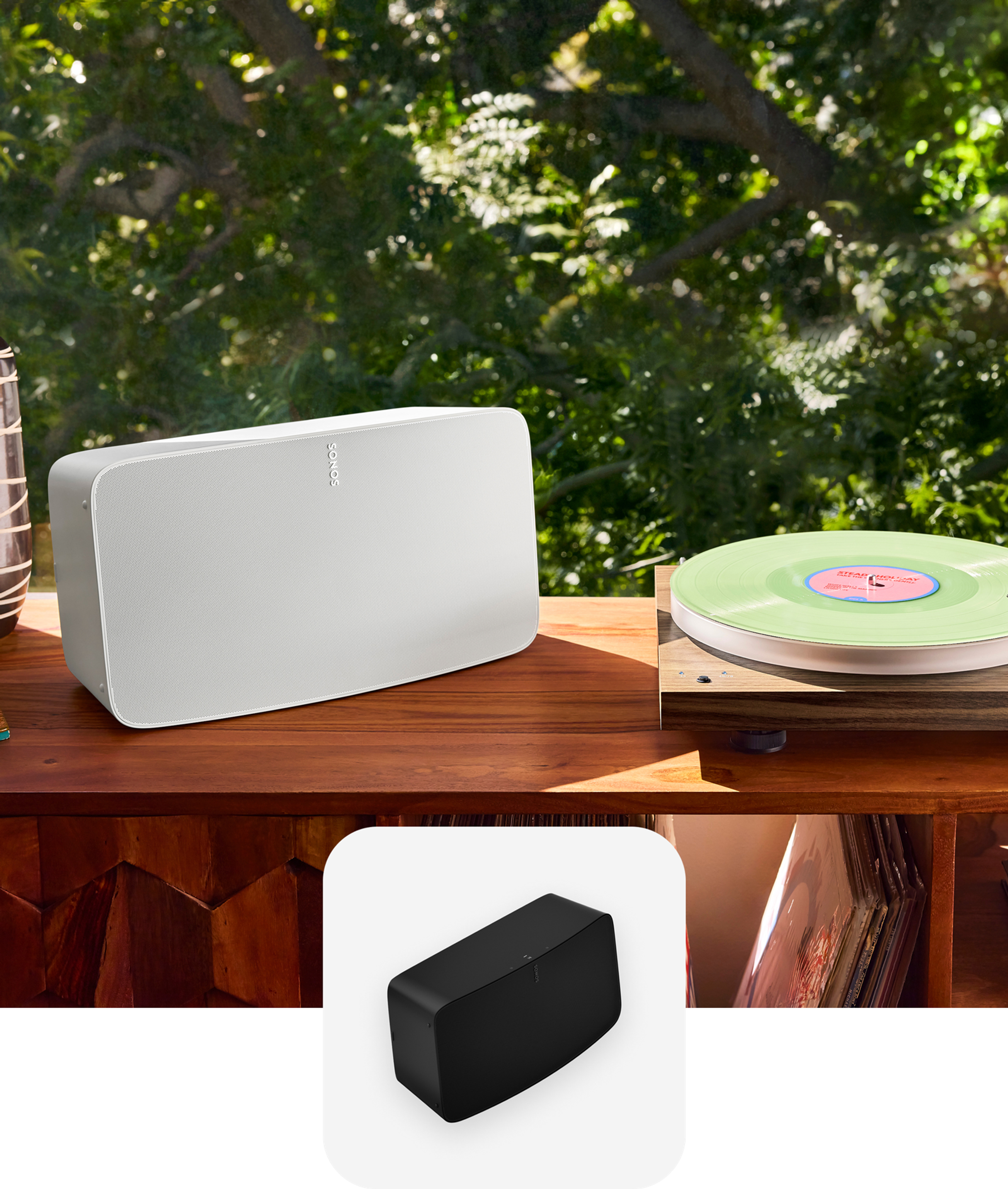A white Sonos Five speaker next to a turntable on a record console