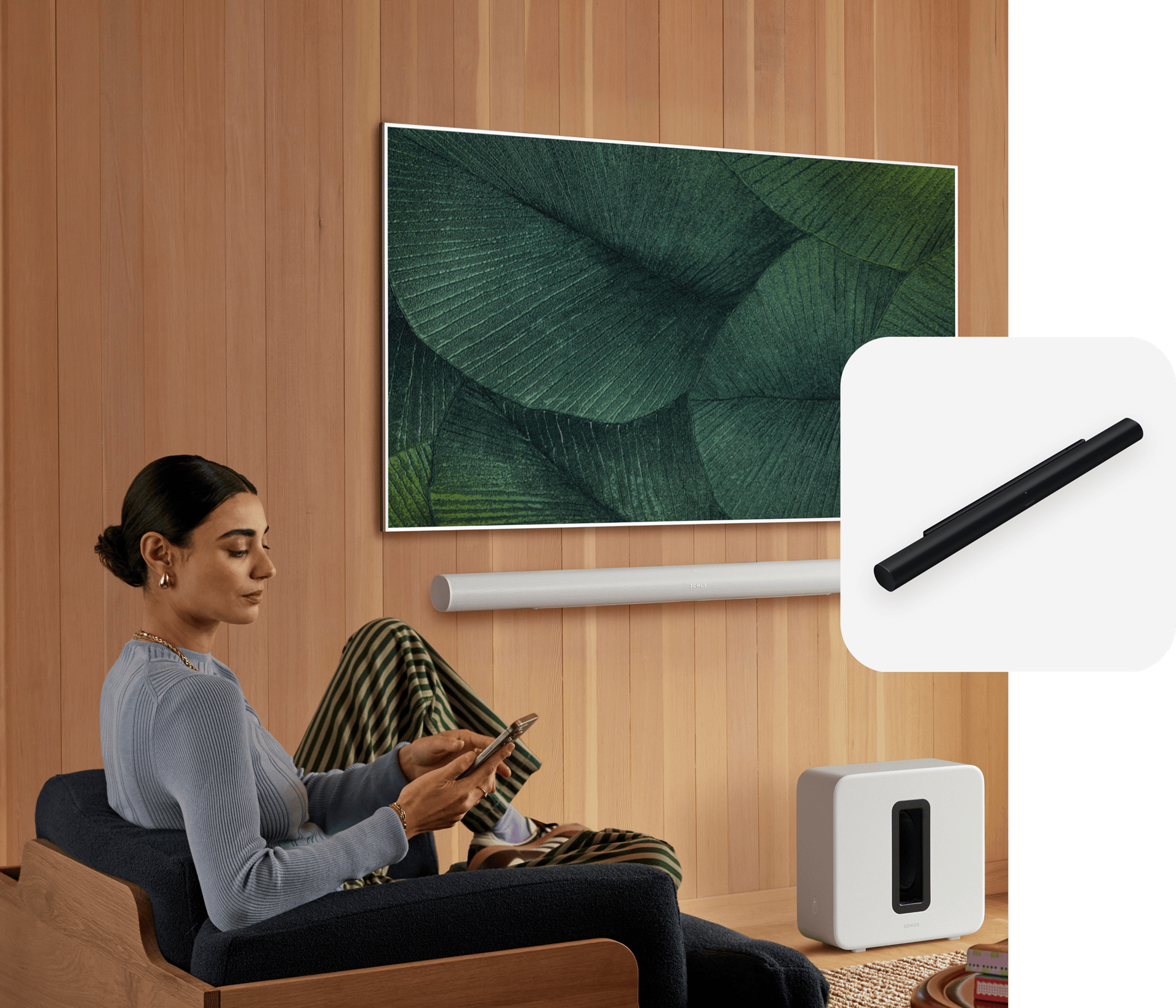 Person sitting and using a phone with Sonos Arc Ultra and TV in the background and an Arc Ultra product tile overlay