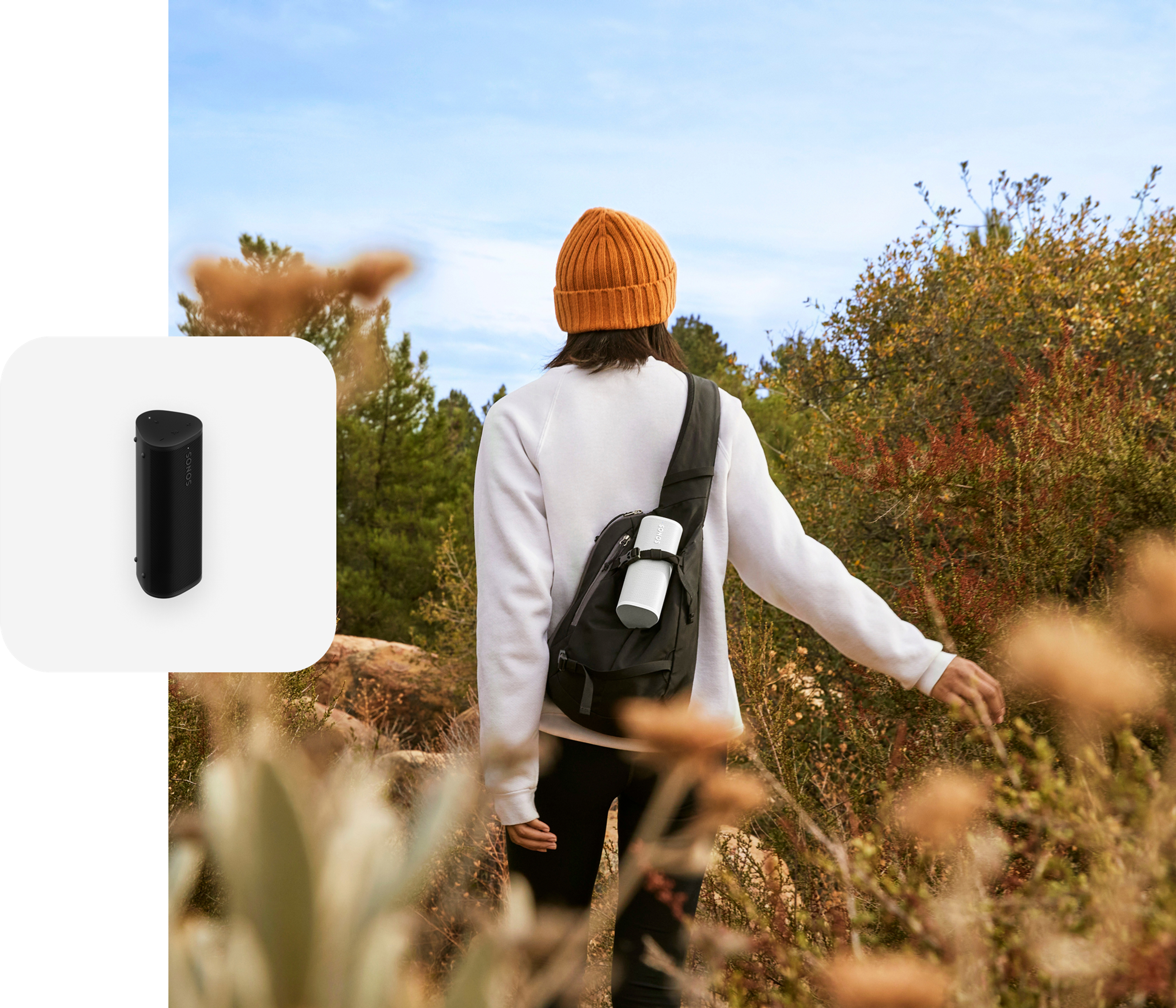 User hiking on a trail listening to a white Roam 2 in their backpack