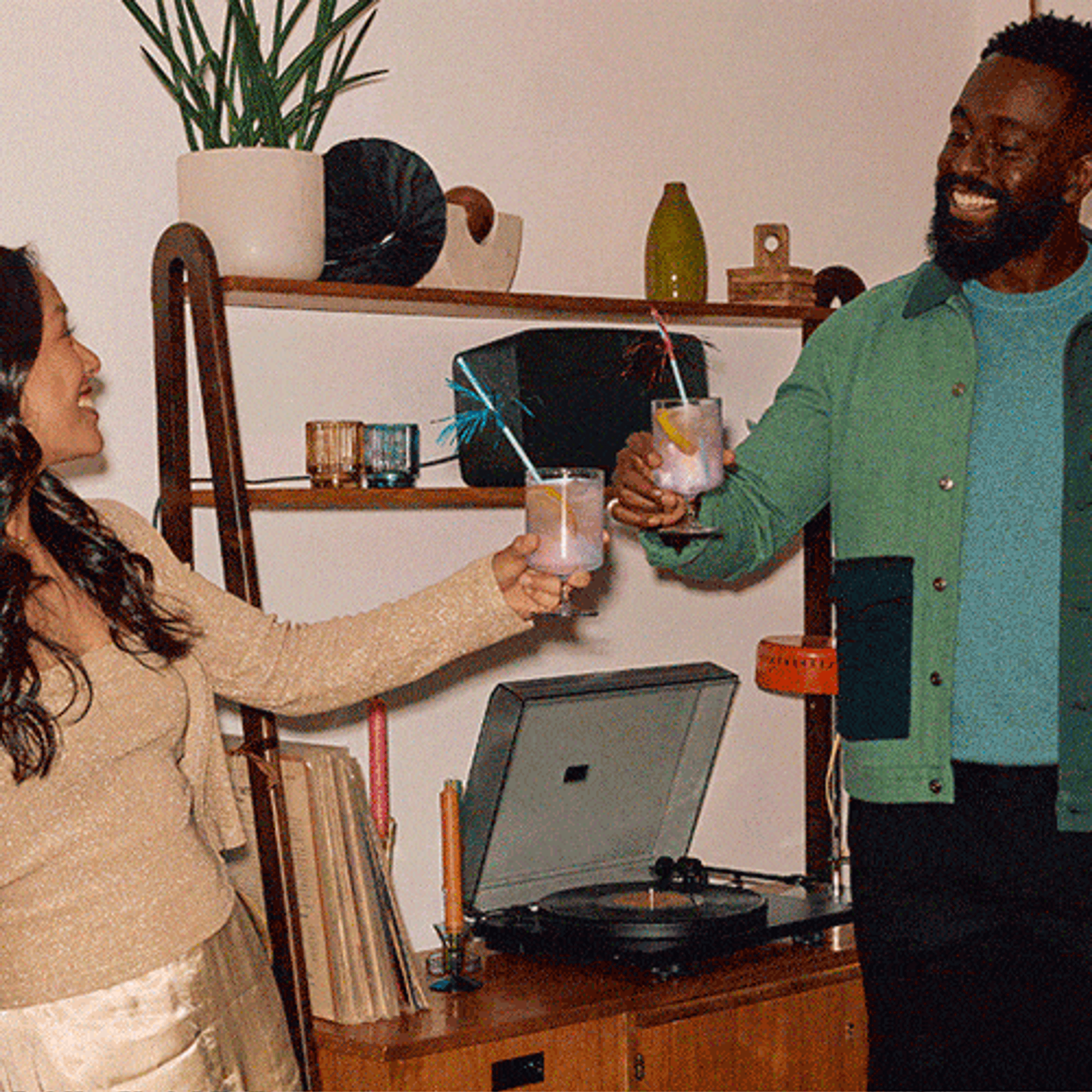 A group of friends at a holiday party drinking cocktails and listening to vinyl on a Sonos Five