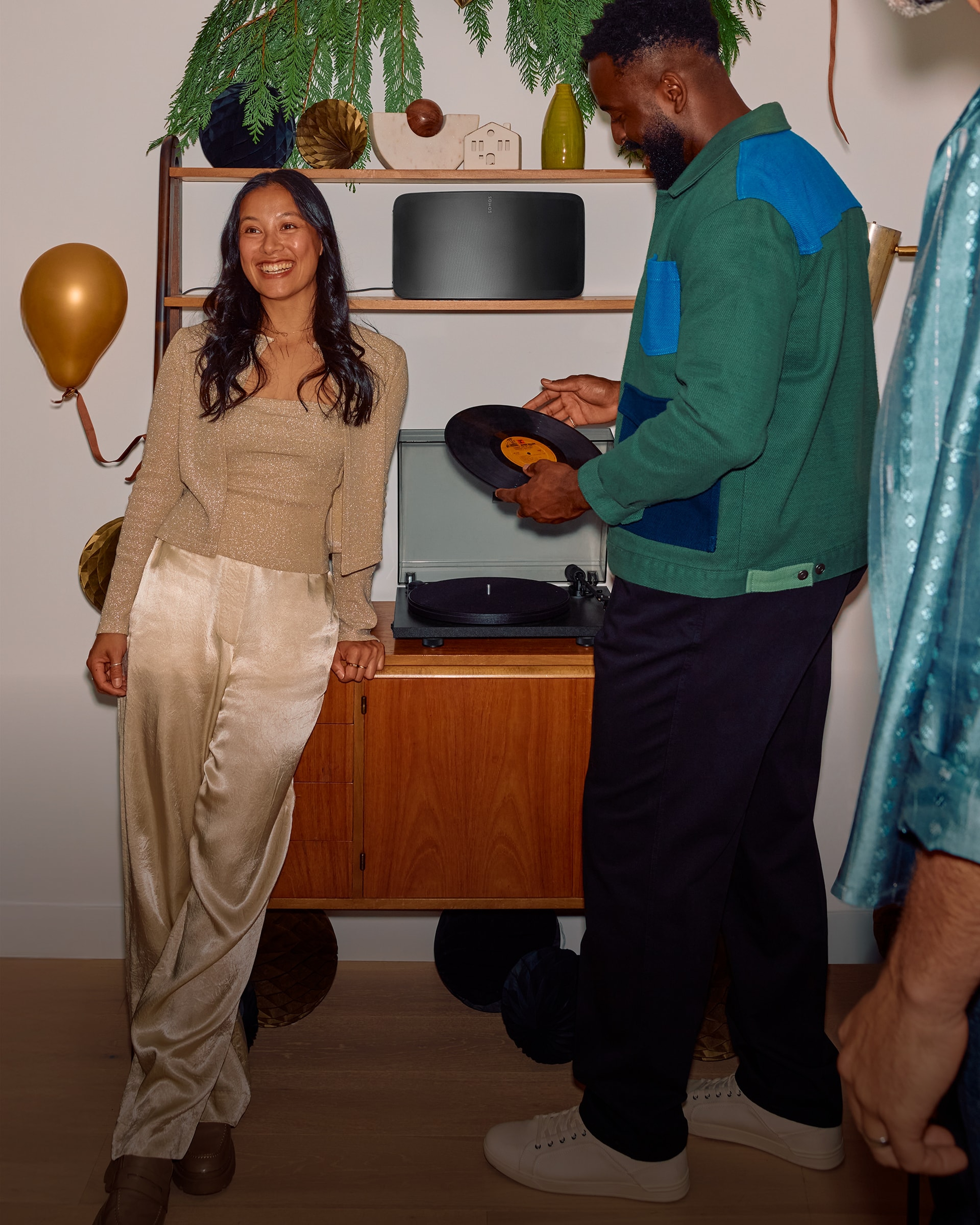 Person at a party placing a record on a turntable