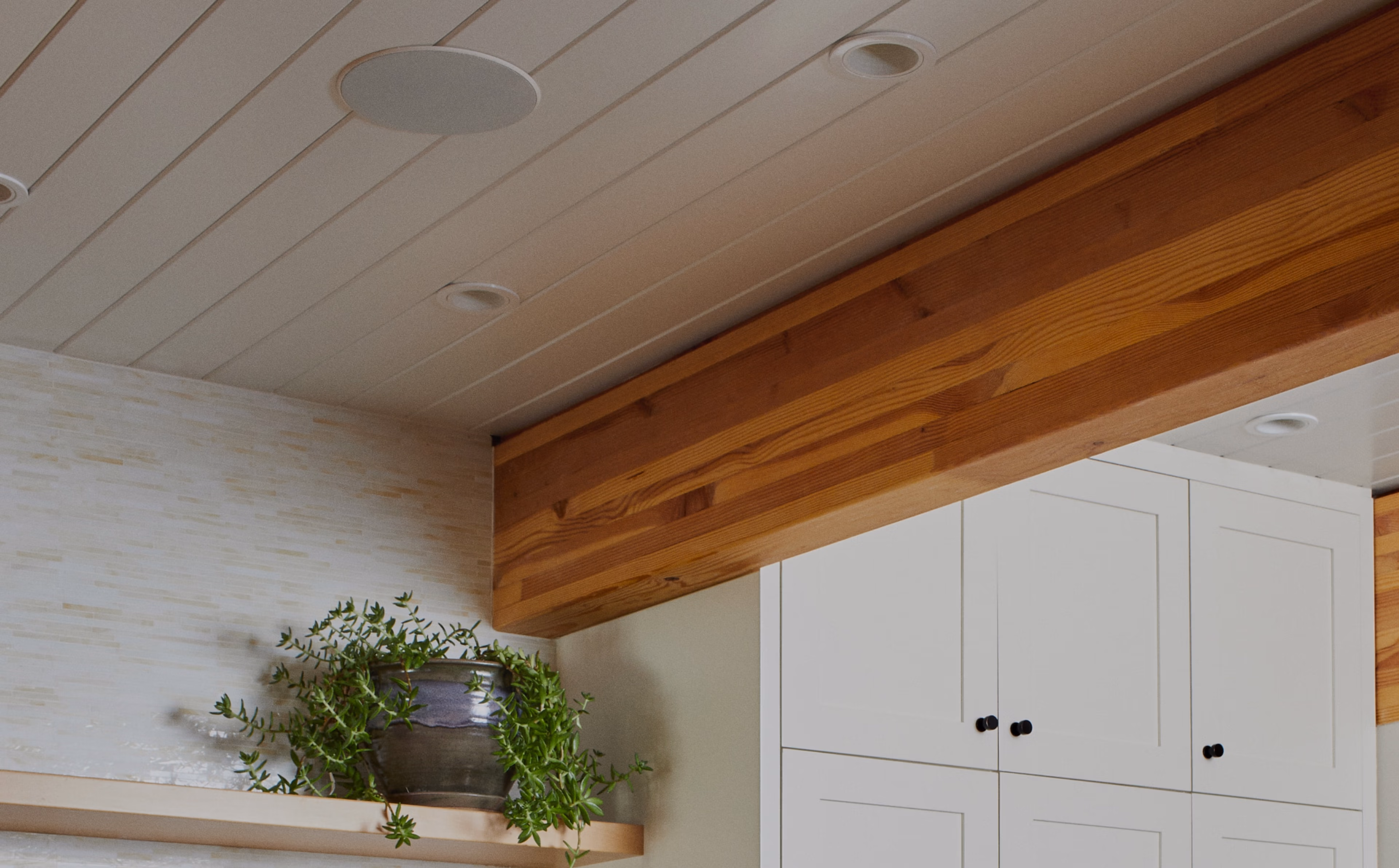 Closeup of Sonos and Sonance in-ceiling speaker installed in ceiling above shelving