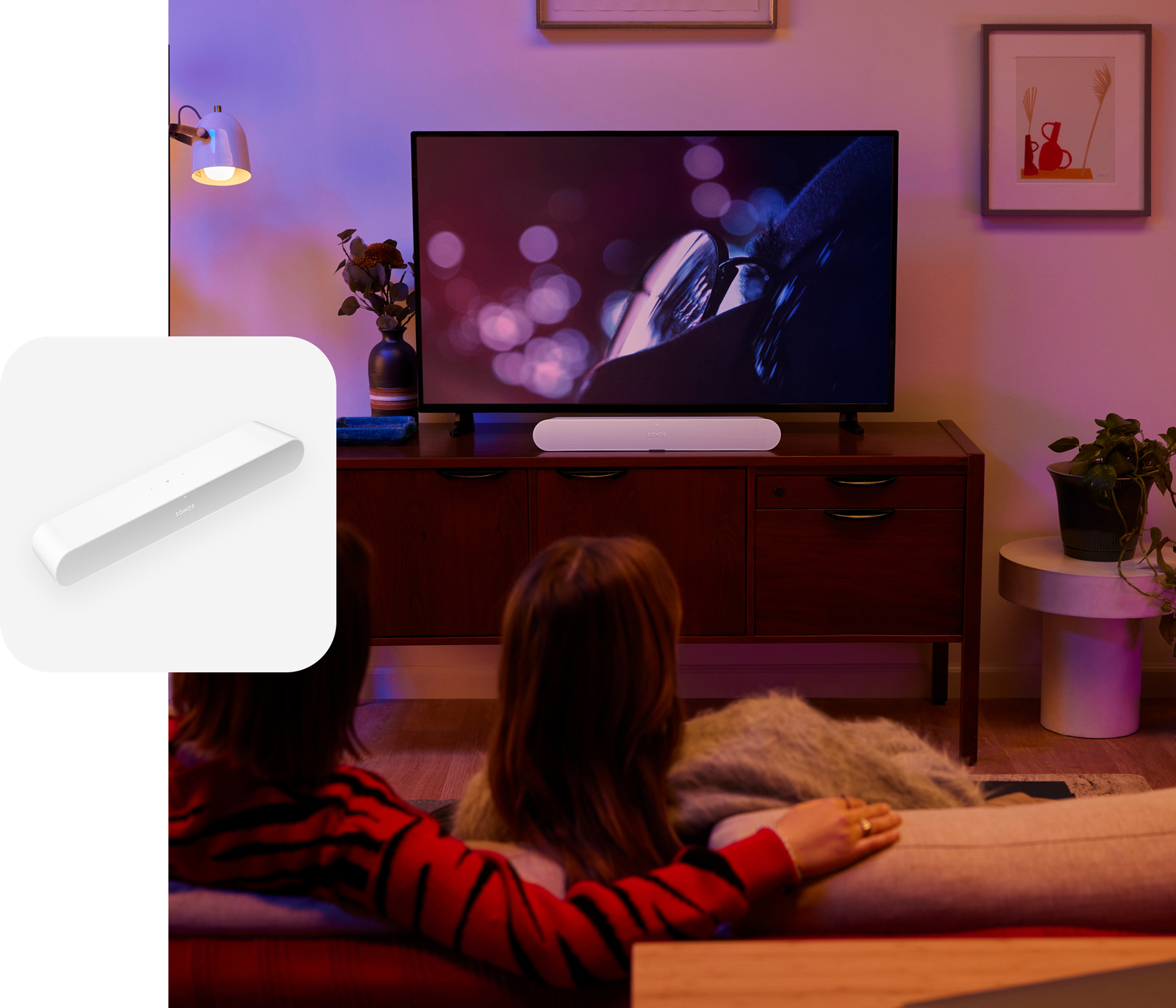 Couple on the couch in their living room watching a film with sound from a white Sonos Ray soundbar