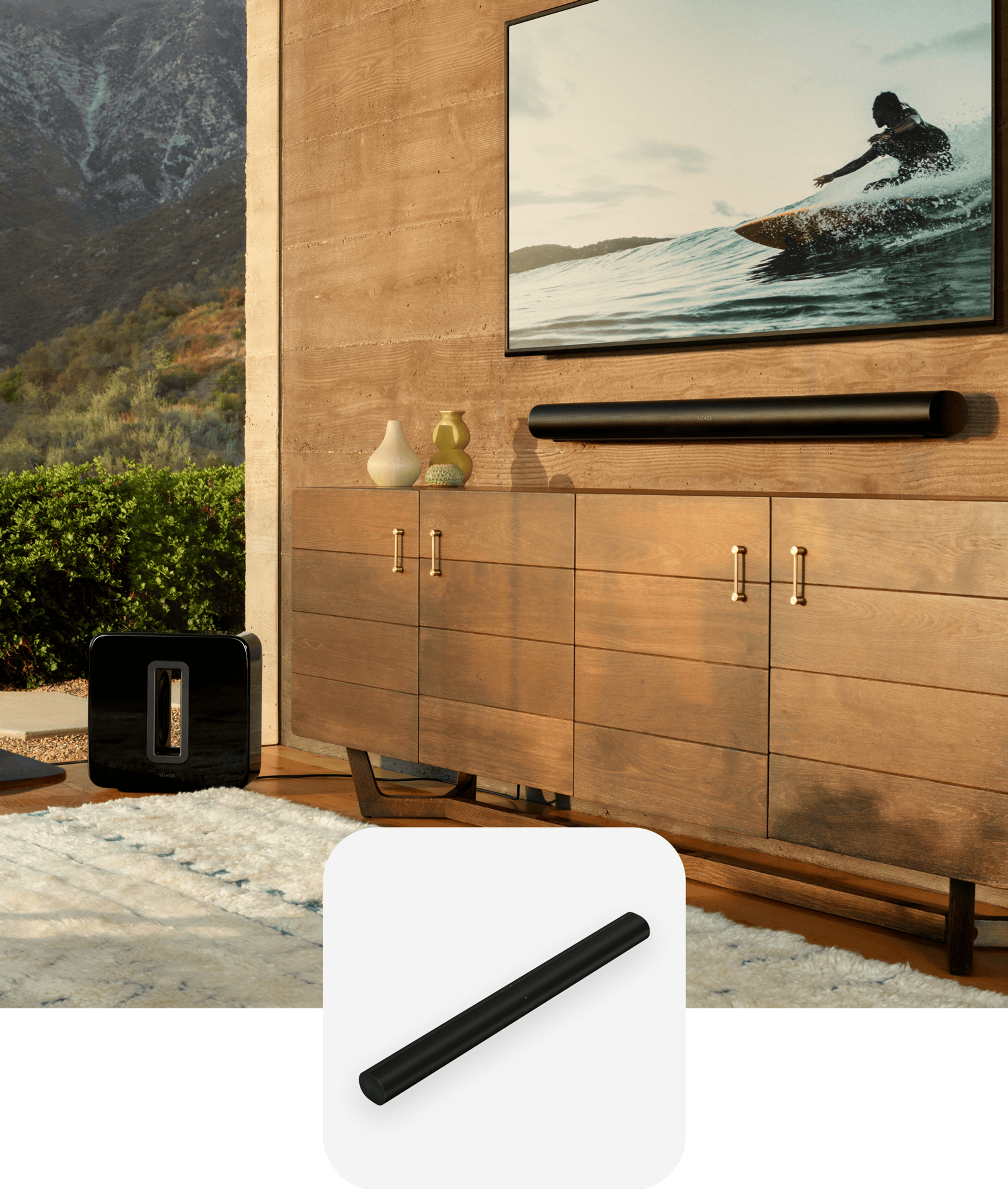 A wall-mounted Sonos Arc below a TV in a living room with a black Sonos Sub