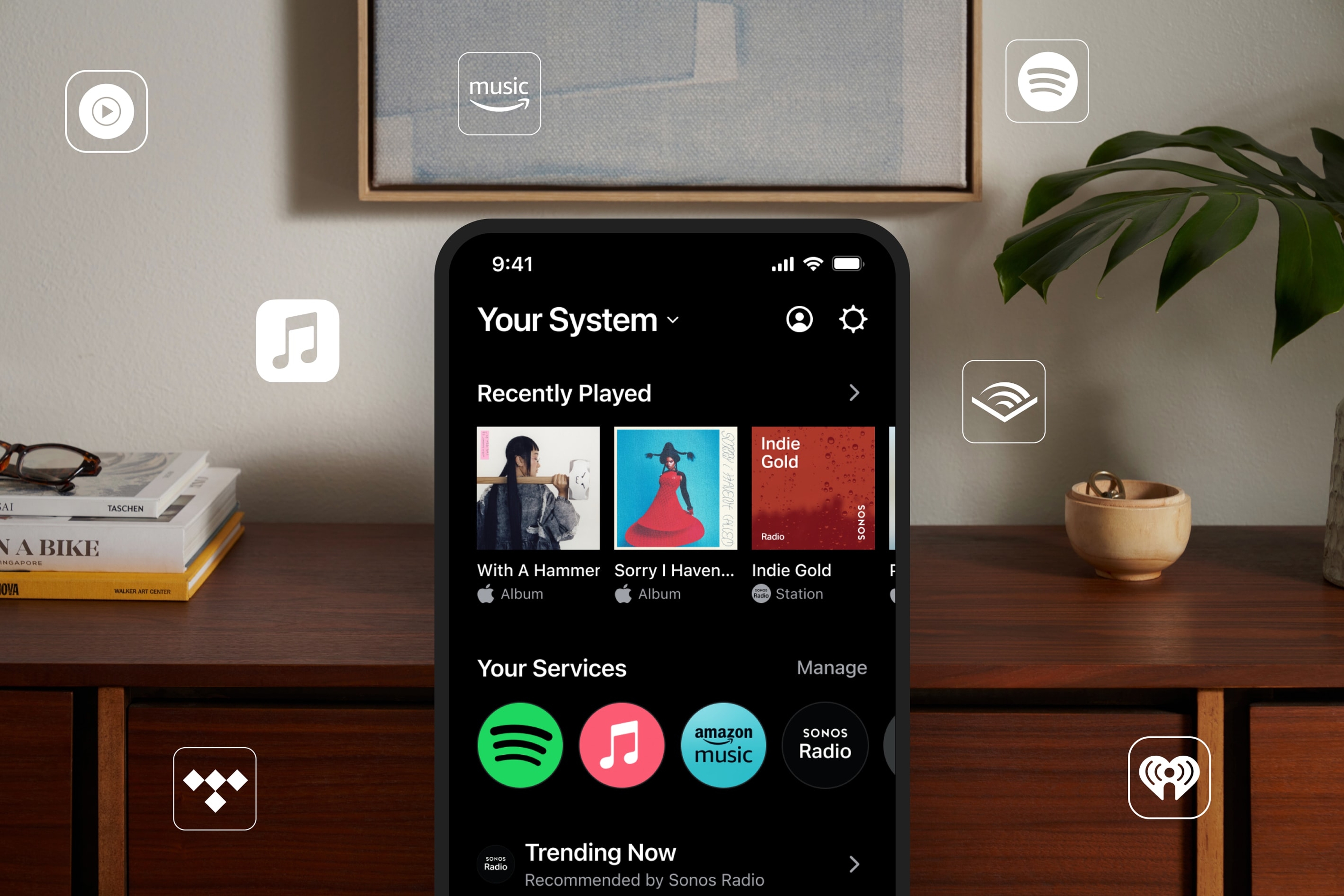 Visual of the Sonos app home screen on a phone with various streaming service logos around it