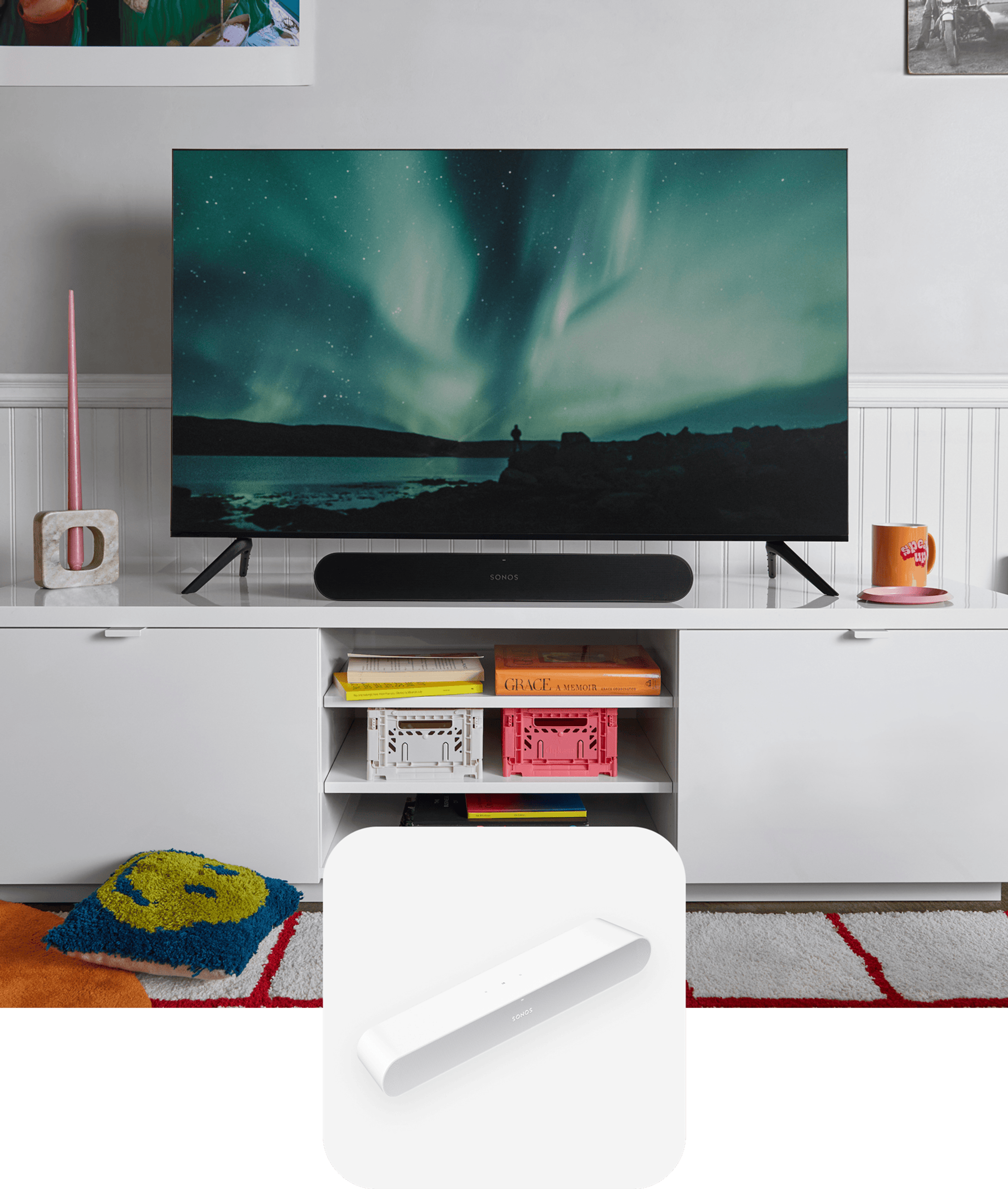 A black Sonos Ray soundbar sitting on a white media console below a TV