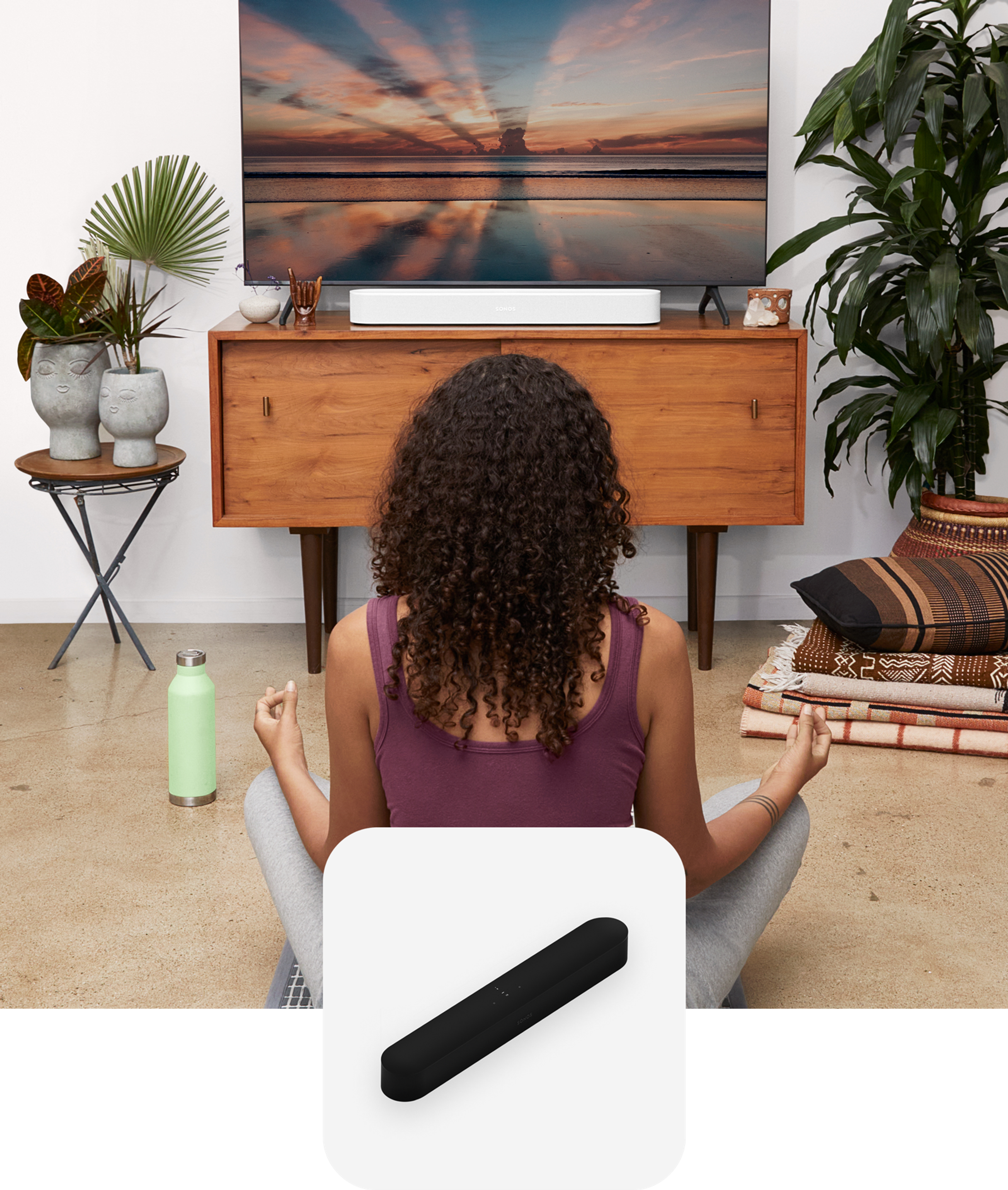 Woman doing yoga in front of TV media console with a white Sonos Beam soundbar