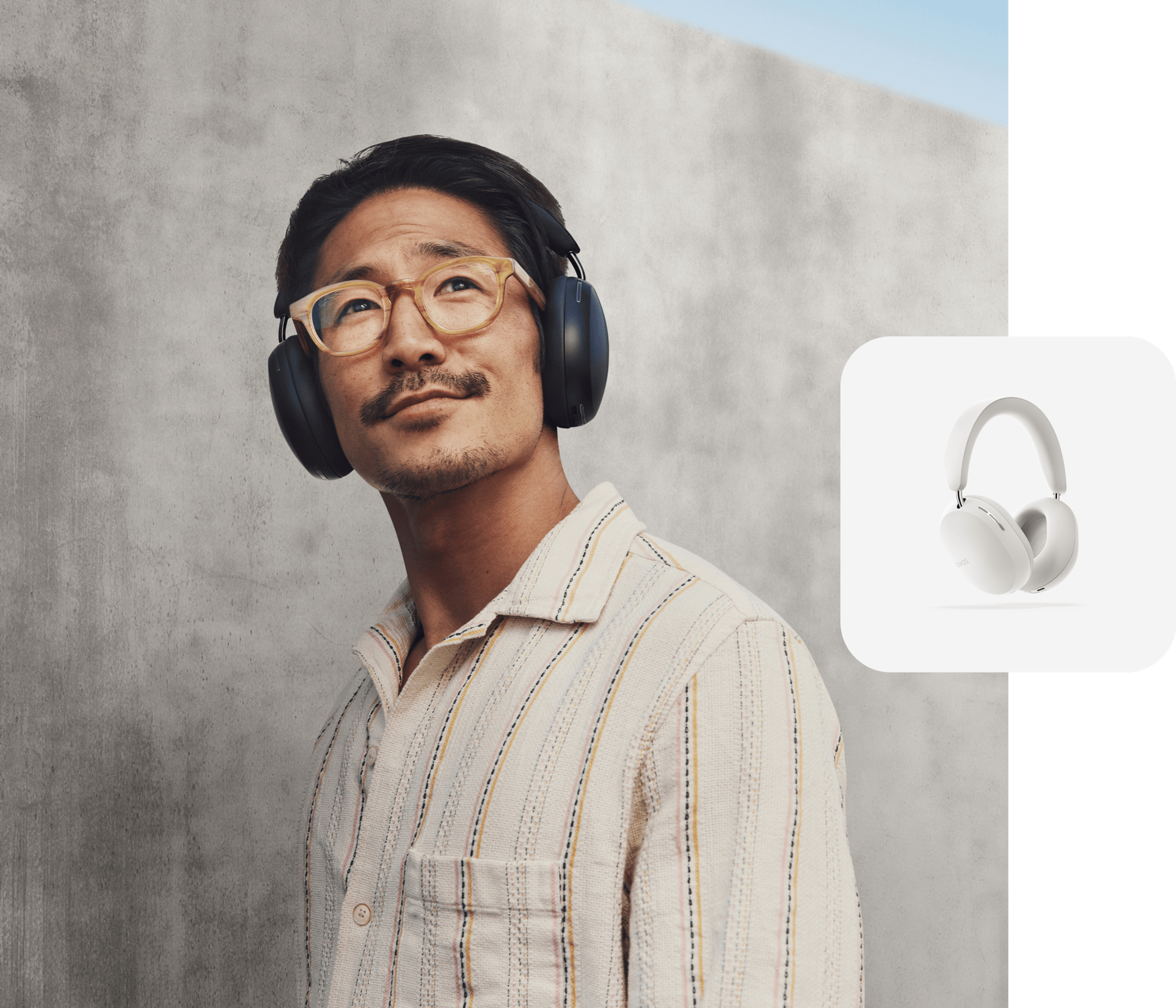 Person smiling listening to music on black Sonos Ace headphones and a white Sonos Ace product tile overlay