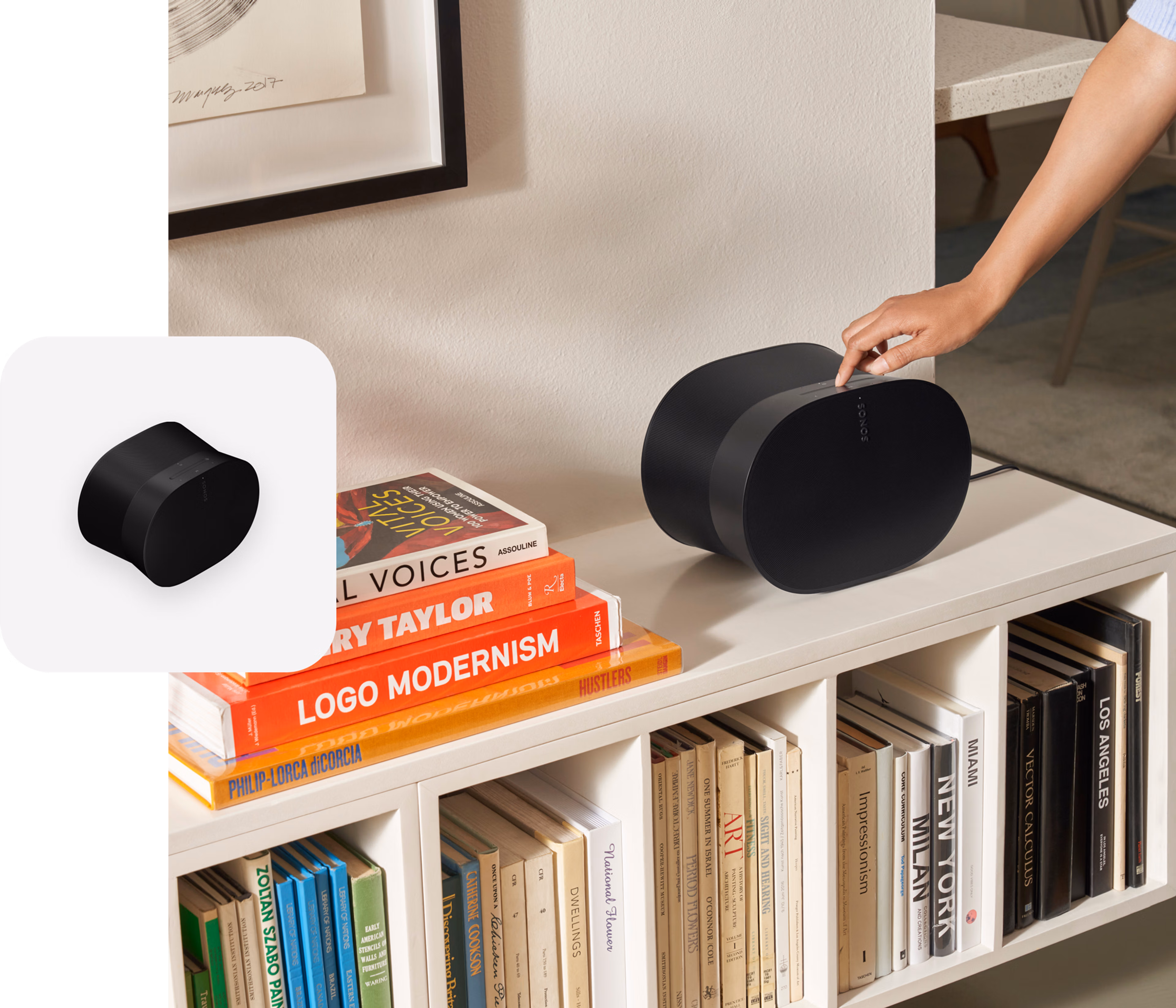 User engaging with the touch controls on a black Era 300 speaker on a white media console