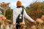 A person carrying a white Sonos Roam strapped to their backpack on a hike