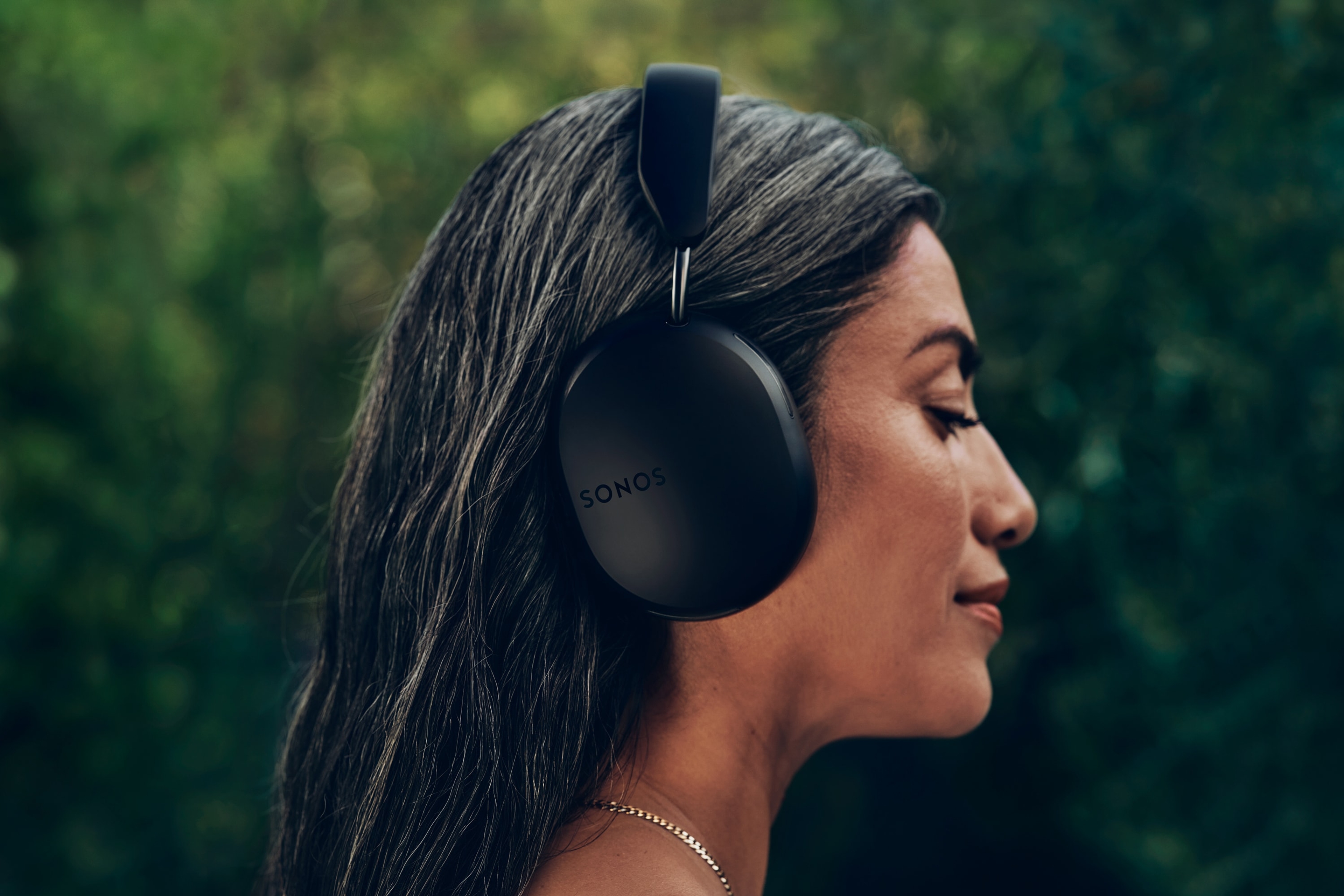 Perfil lateral de una persona con unos auriculares Sonos Ace en negro