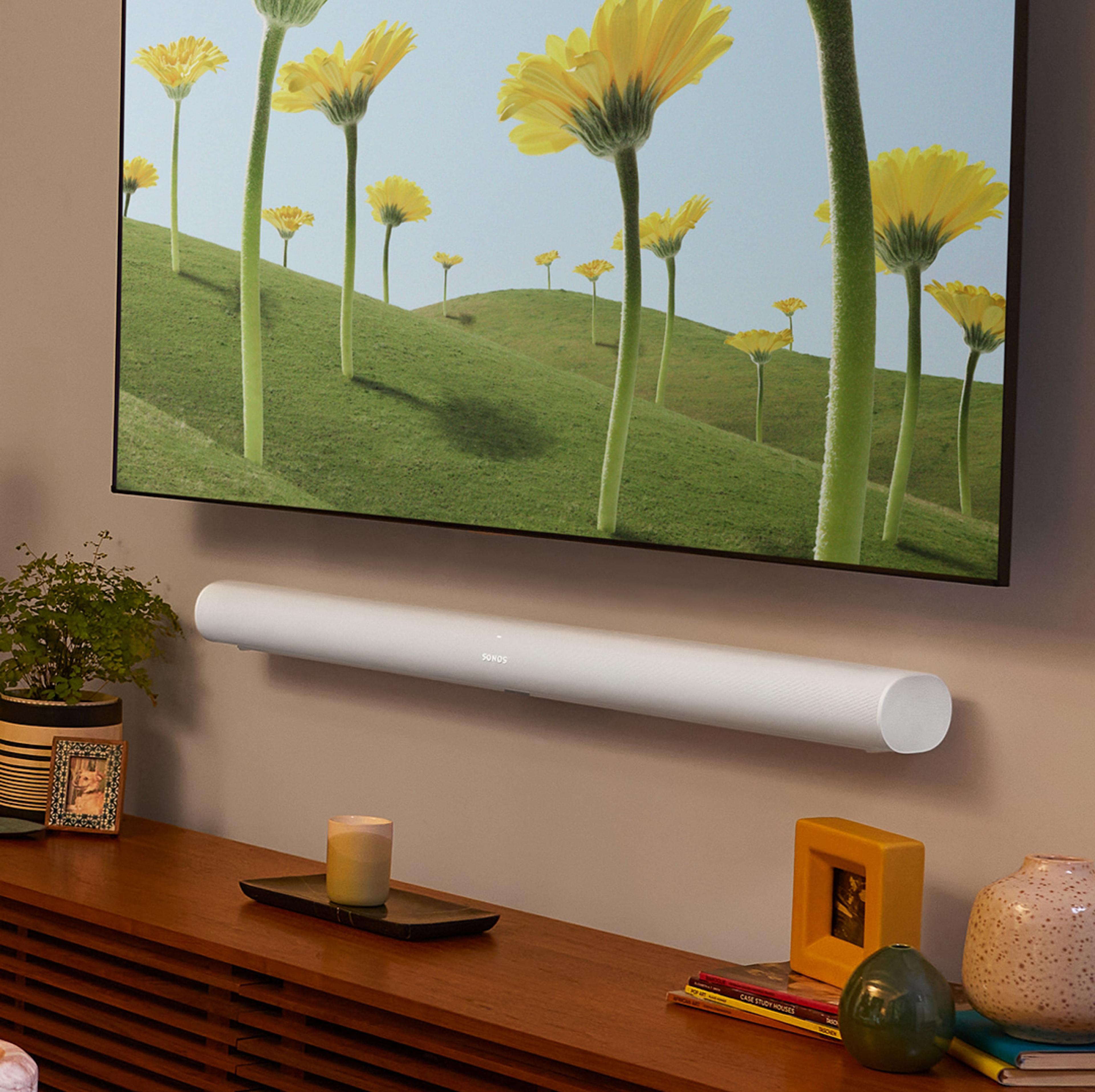 White Sonos Arc mounted on the wall below the TV