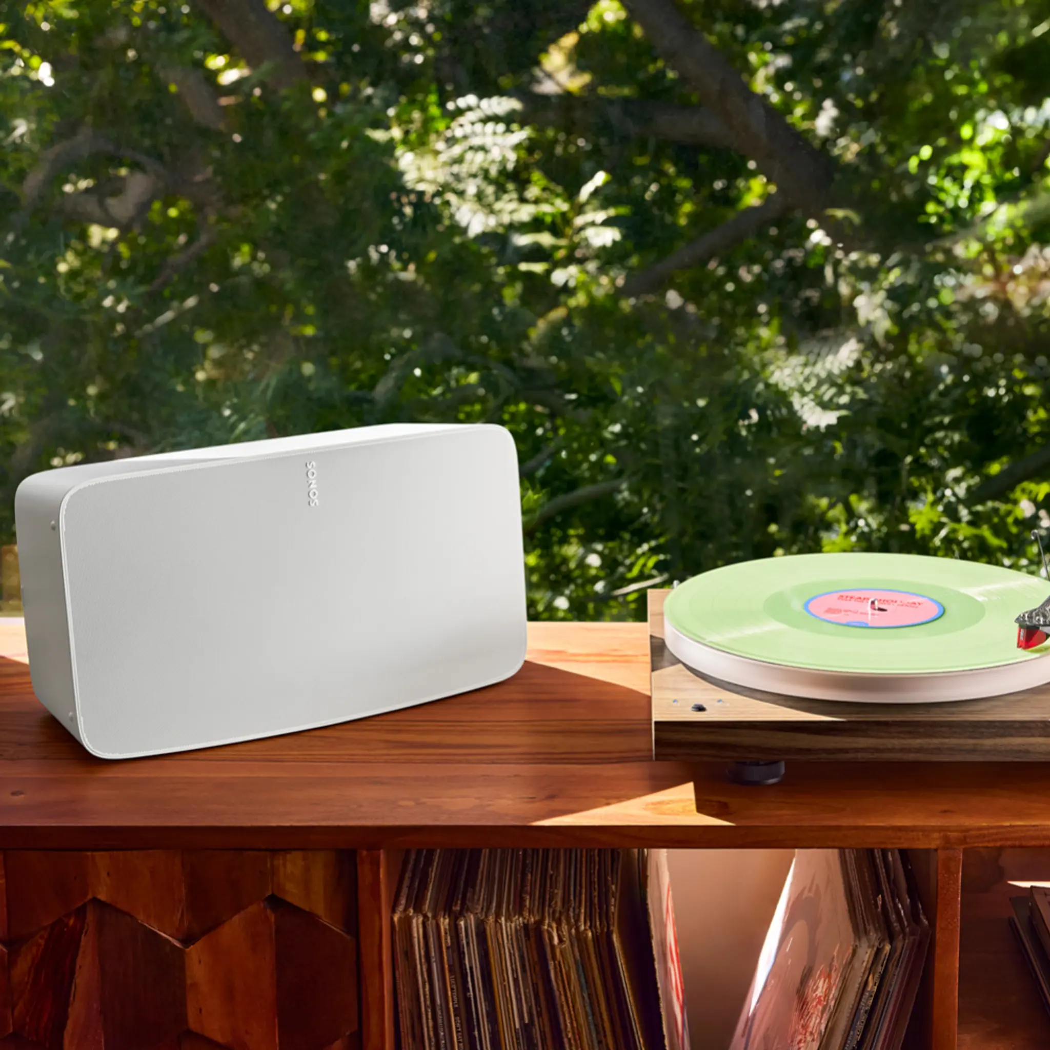 A Sonos Five sitting next to a turntable