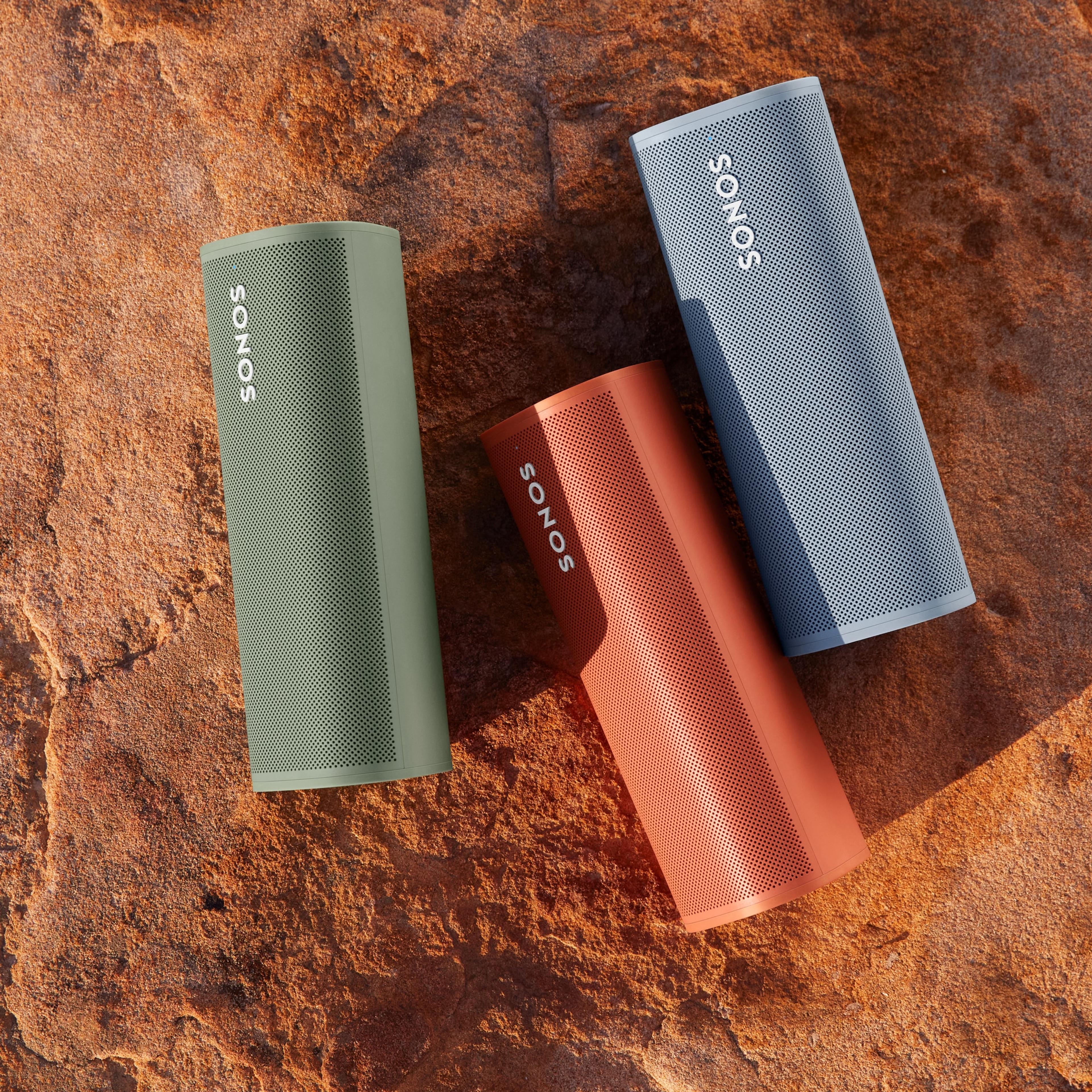 Three Sonos Roam speakers in Olive, Sunset, and Wave