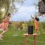 A group of kids playing in sprinklers outside with a black Sonos Move 2 playing music