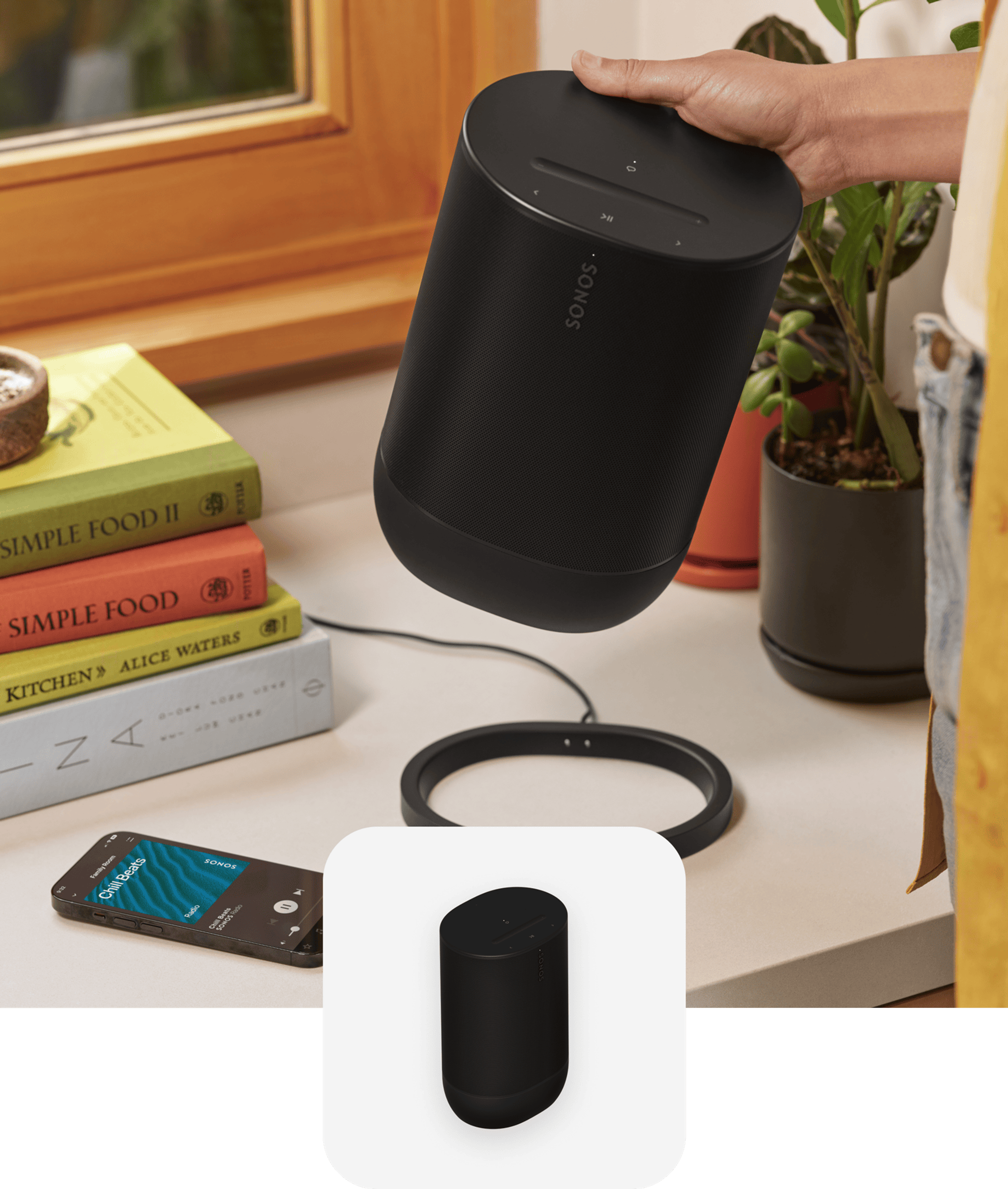 User in the kitchen removing a black Move 2 from its charging base