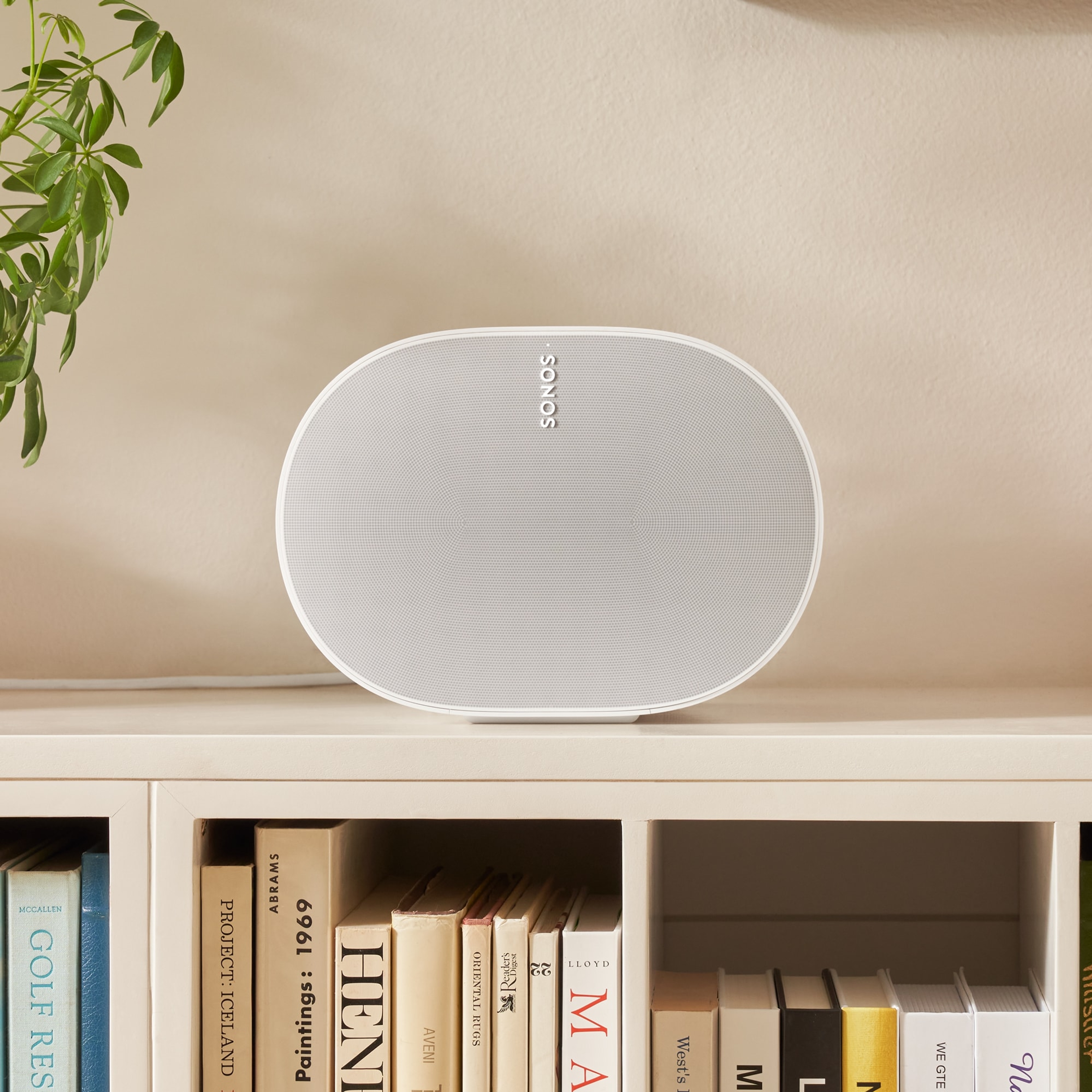 The intricate front grille of a white Era 300 speaker sitting on a low bookshelf