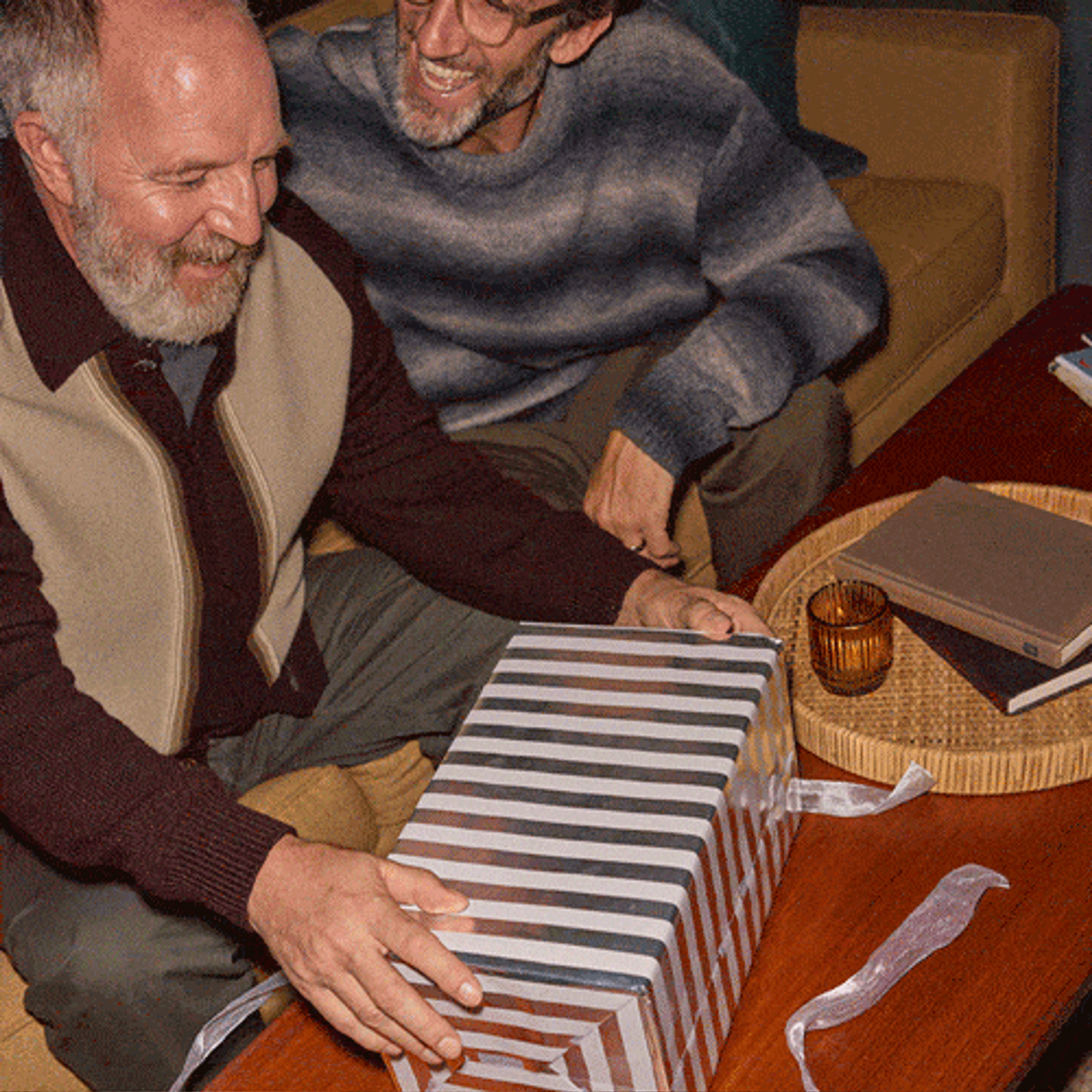 A dad unwrapping a holiday gift of Sonos Move 2 from his son