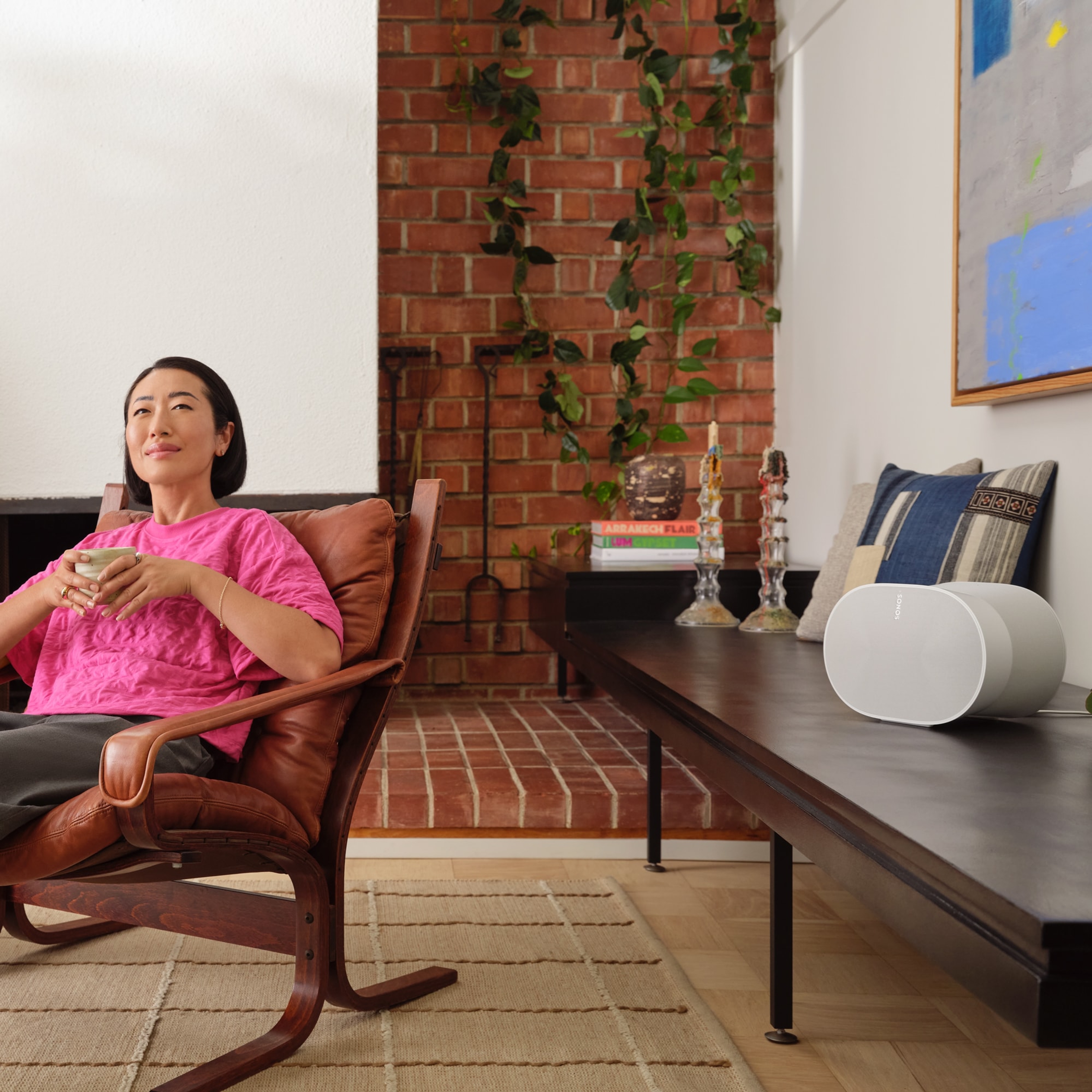 The immersive sound of a white Era 300 filling a user's living room as she enjoys her morning coffee