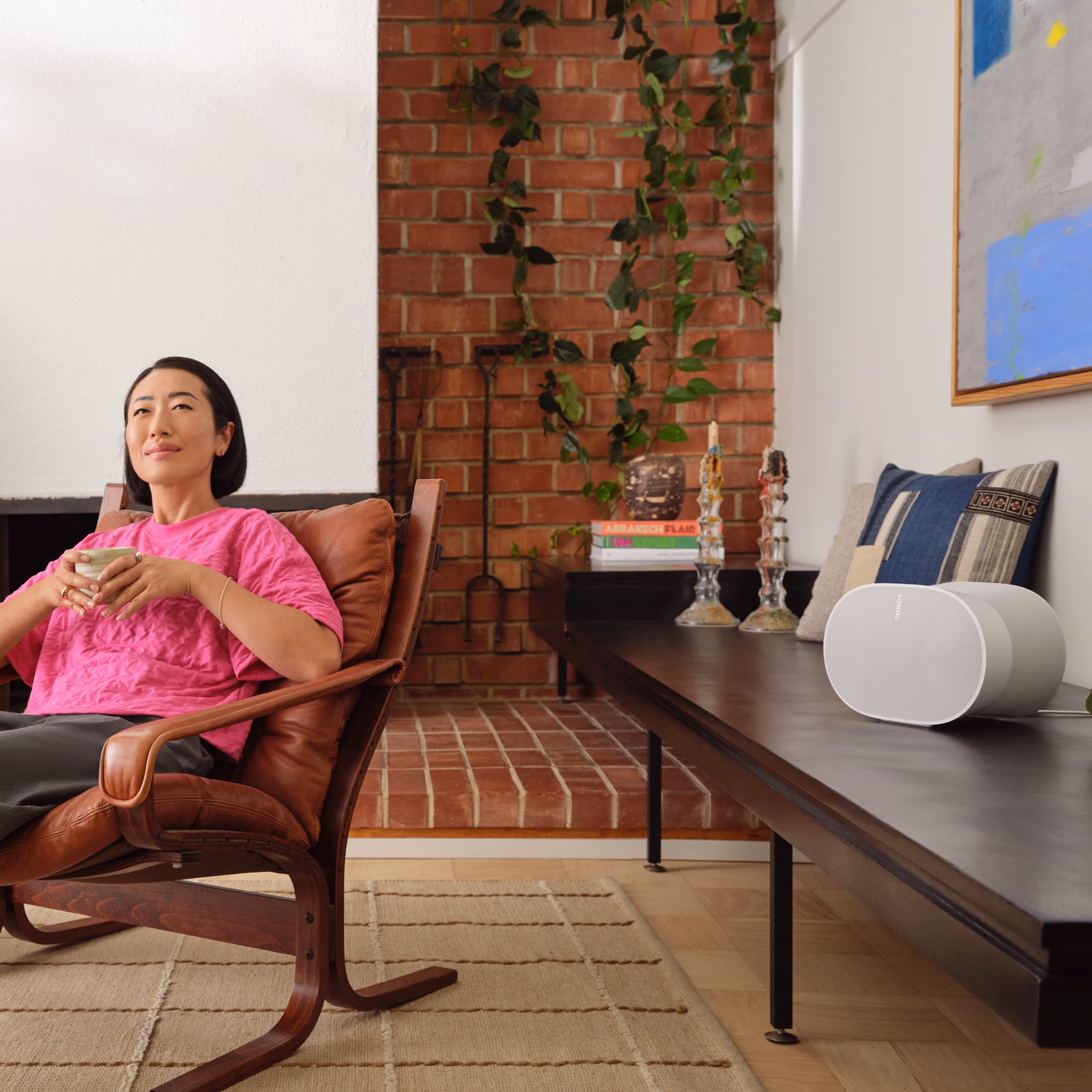 The immersive sound of a white Era 300 filling a user's living room as she enjoys her morning coffee