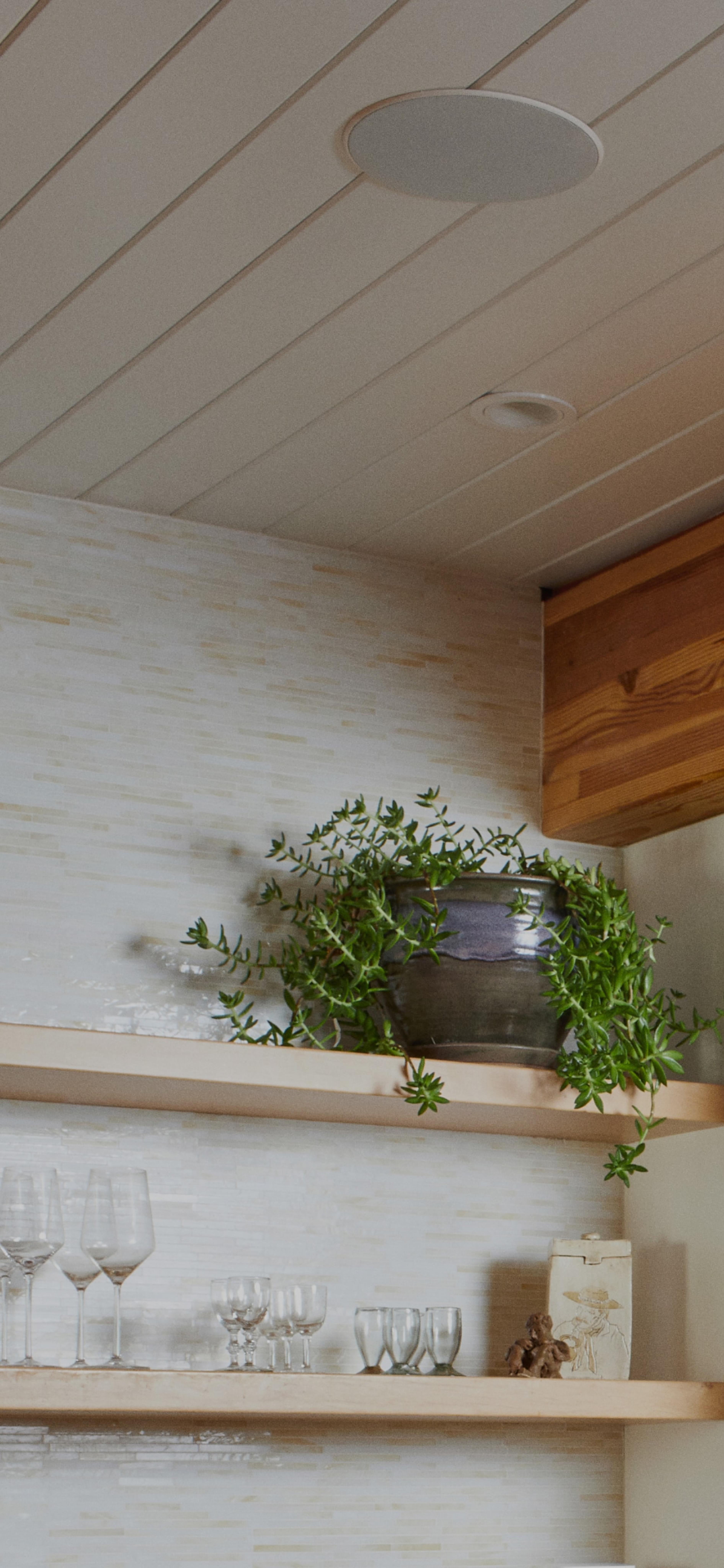 Closeup of Sonos and Sonance In-Ceiling speaker installed in ceiling above shelving