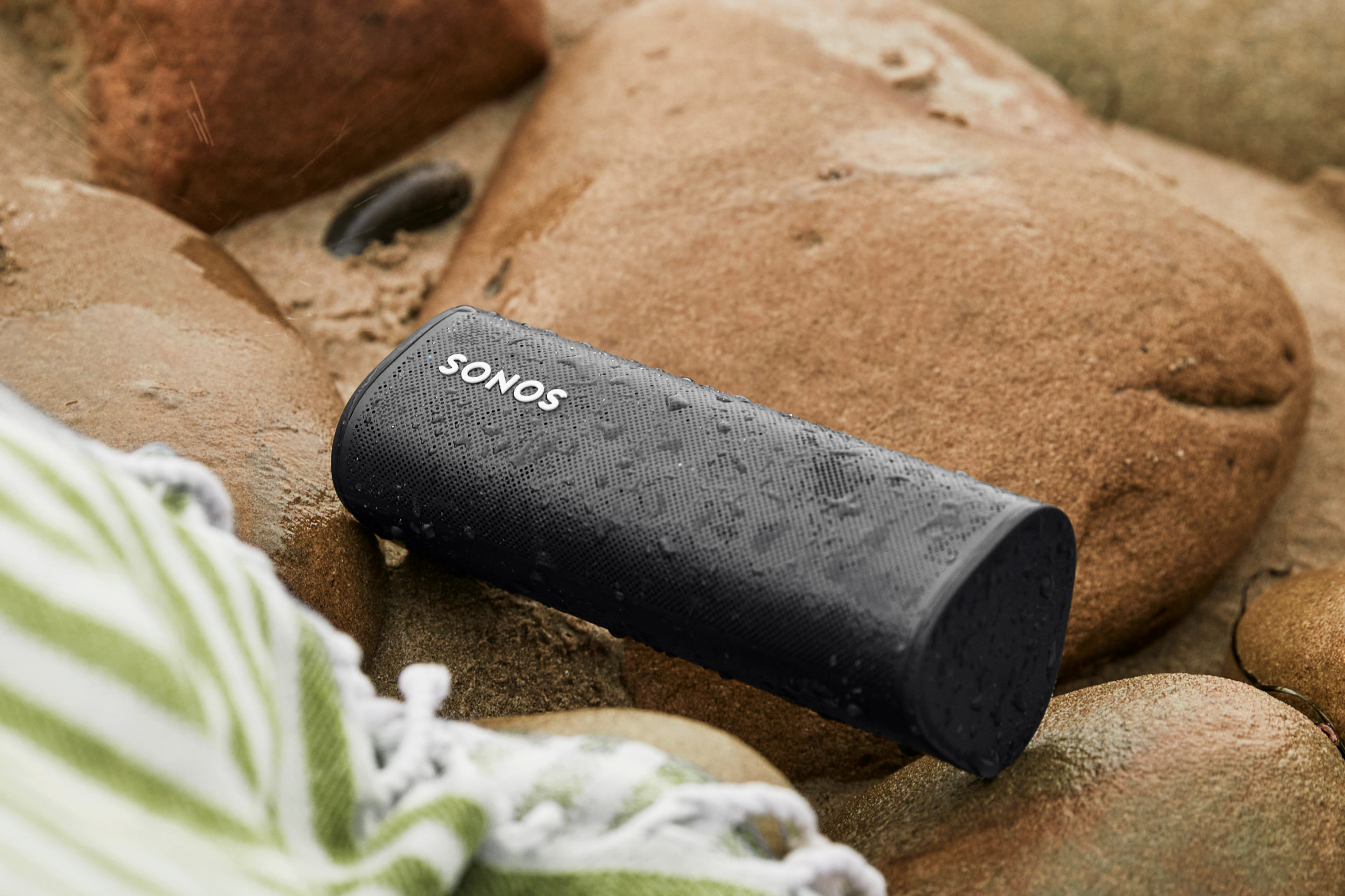 Roam speaker in Olive being used outdoors near waterfall
