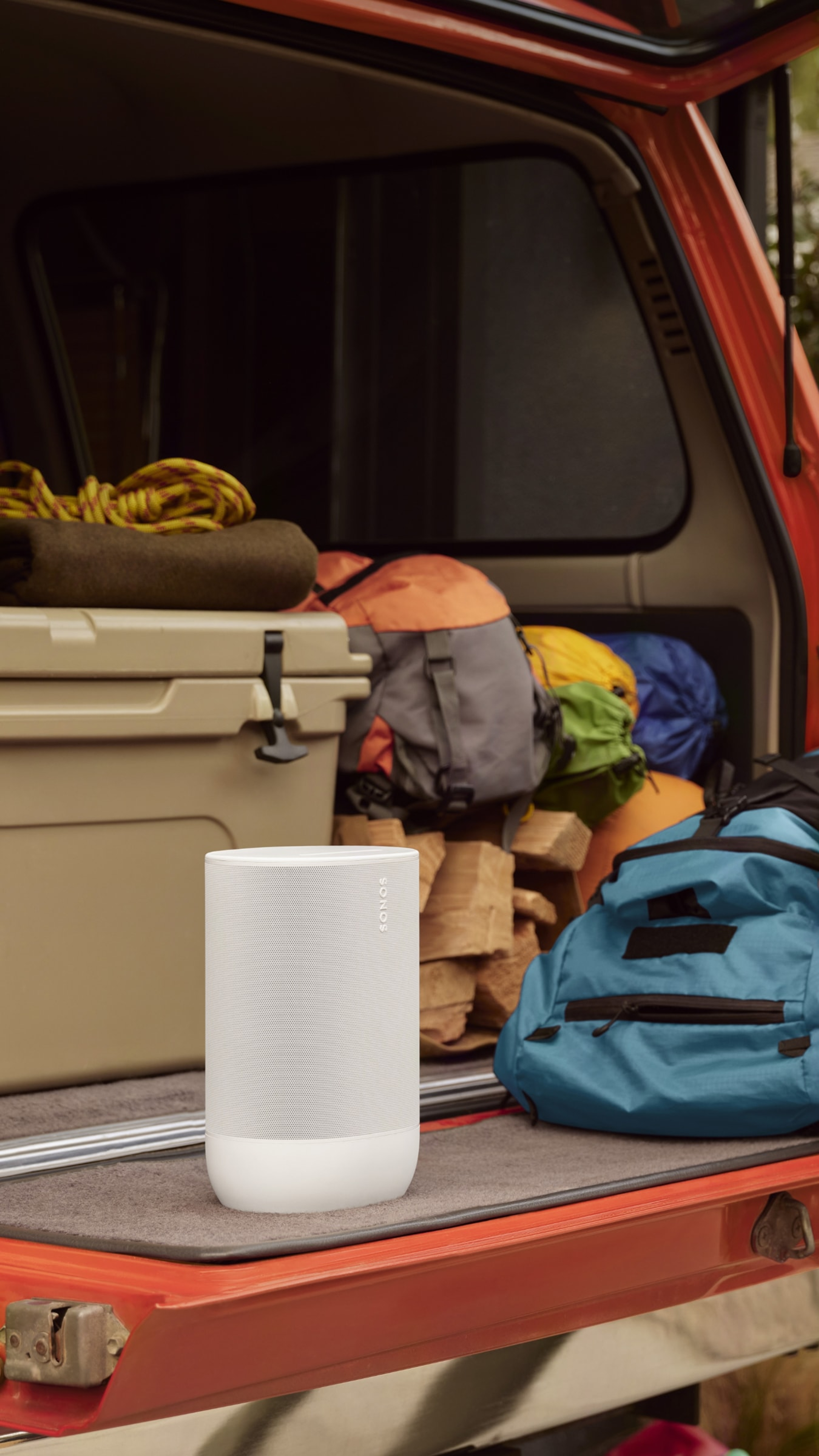 Tragbarer Sonos Move 2 in Weiß auf einem Truck neben Campingausrüstung