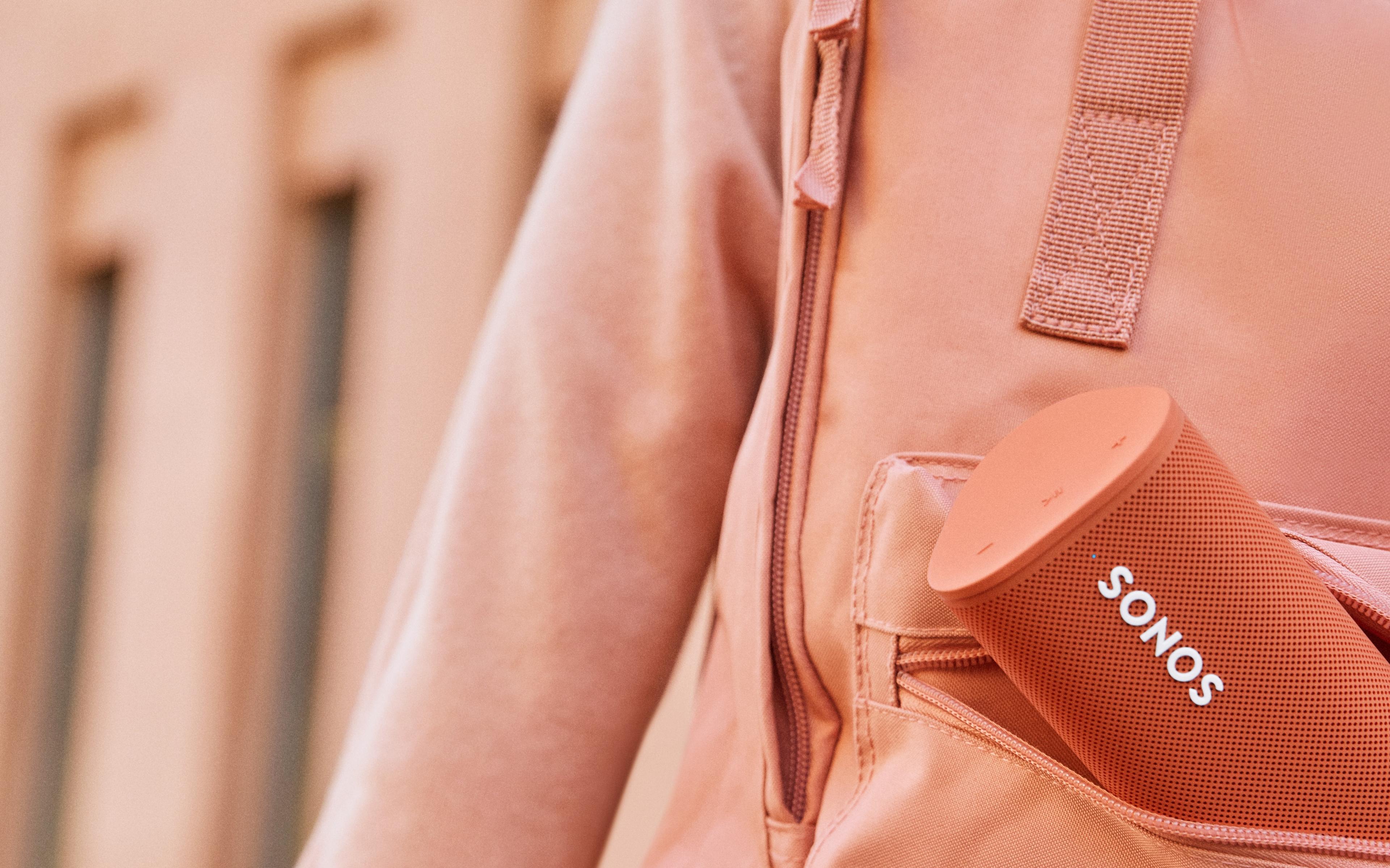 Closeup of Roam speaker in Sunset being carried in a backpack