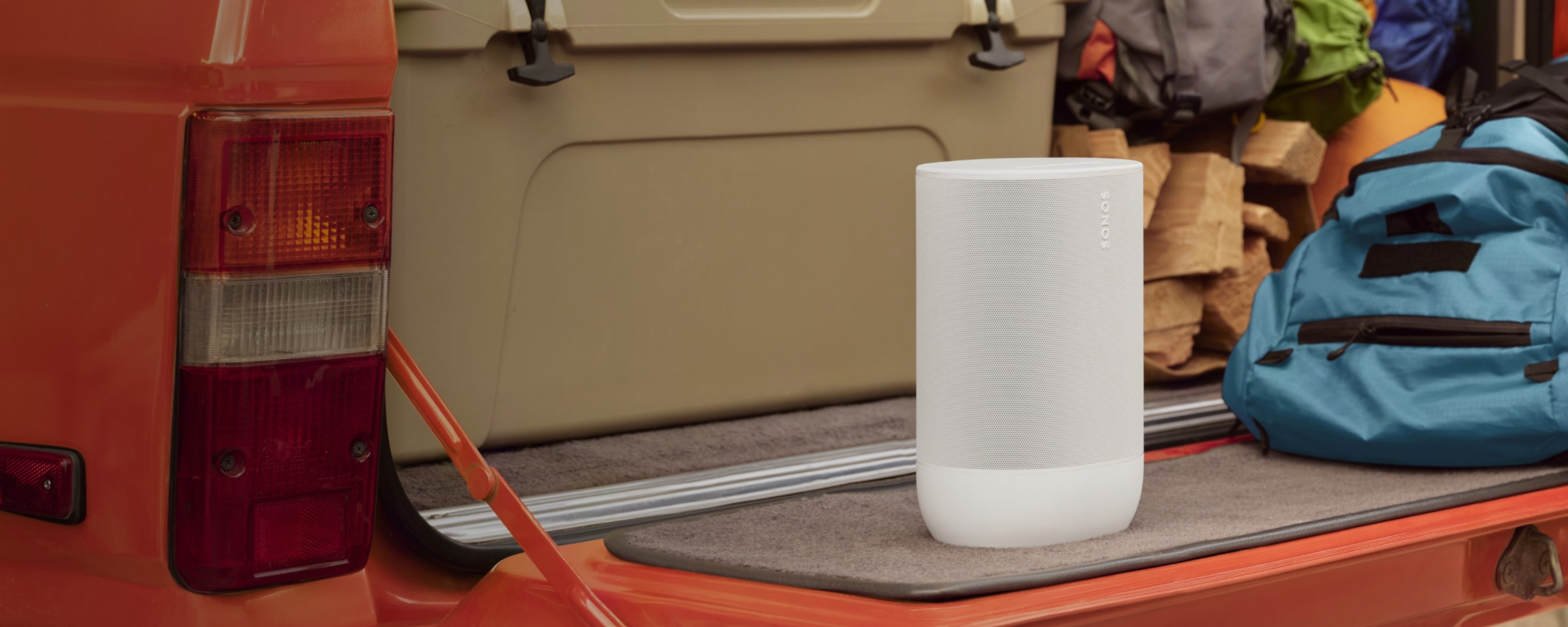 Tragbarer Sonos Move 2 in Weiß auf einem Truck neben Campingausrüstung