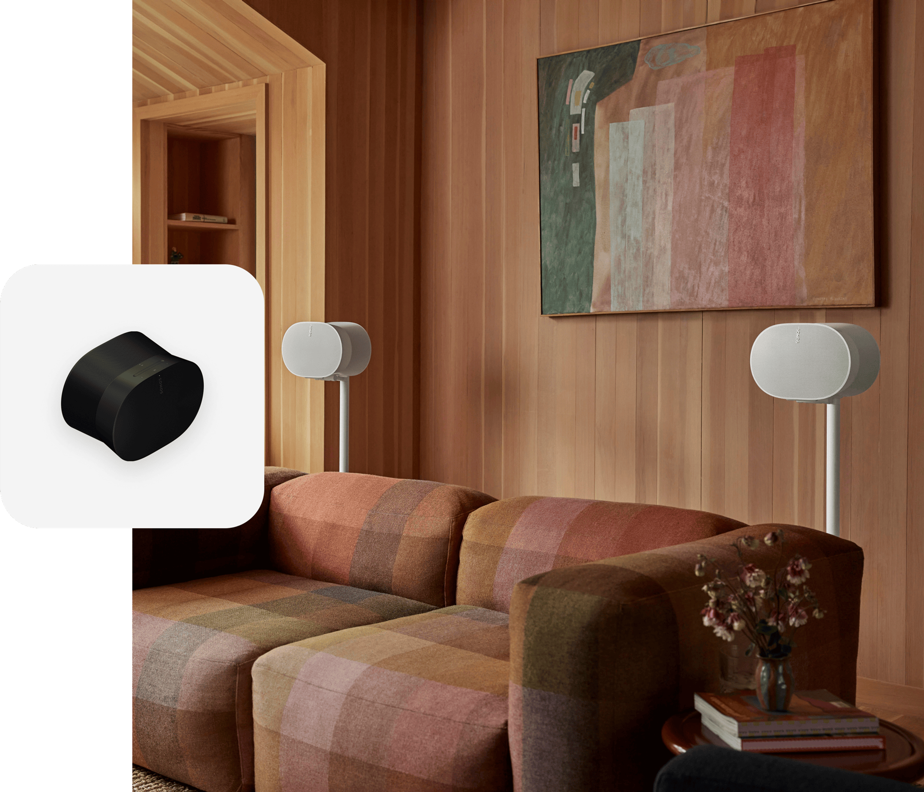 A pair of white Era 300 speakers on stands setup behind a couch for surround sound