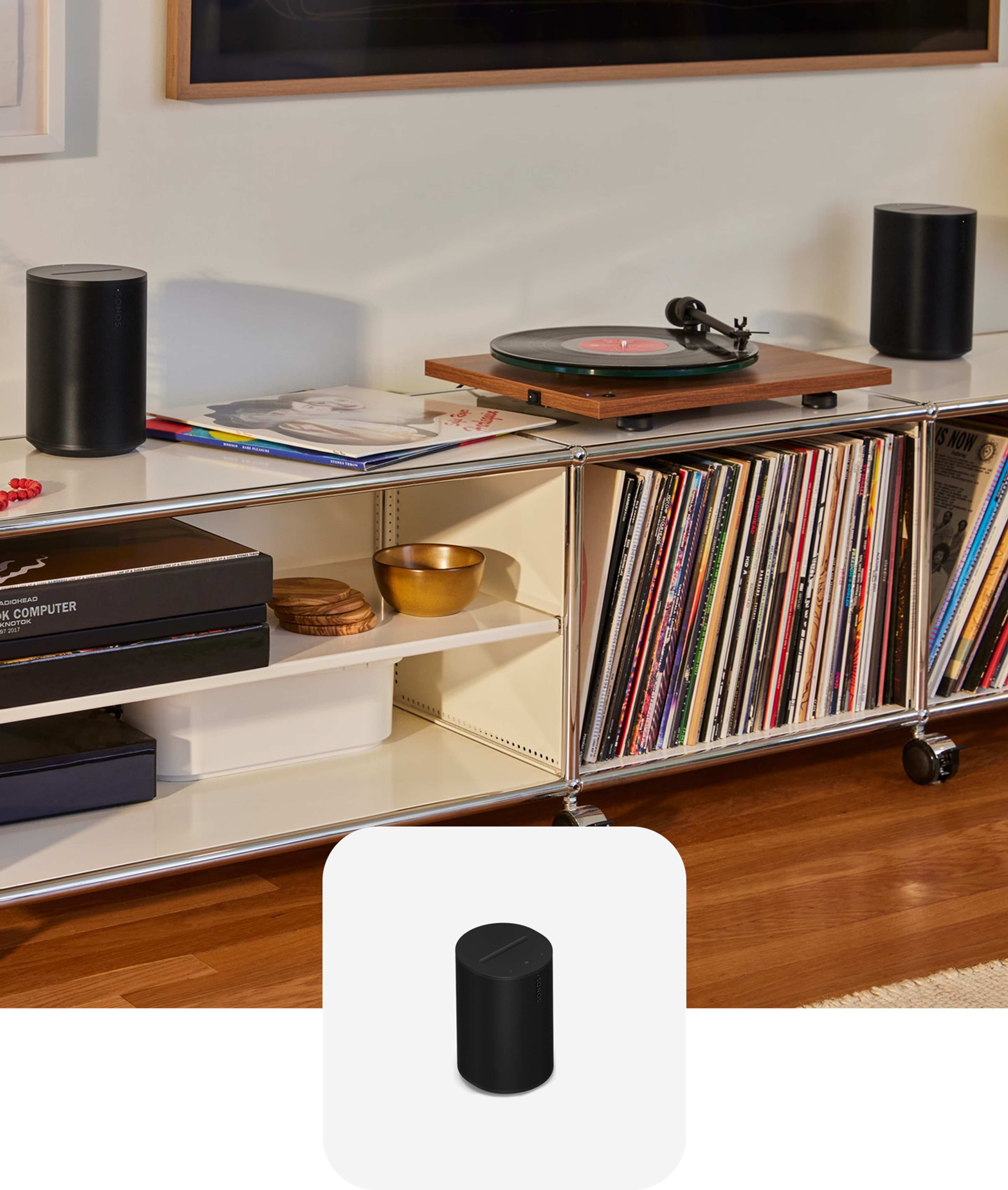 A pair of black Sonos Era 100 SL speakers on a record console connected to a turntable