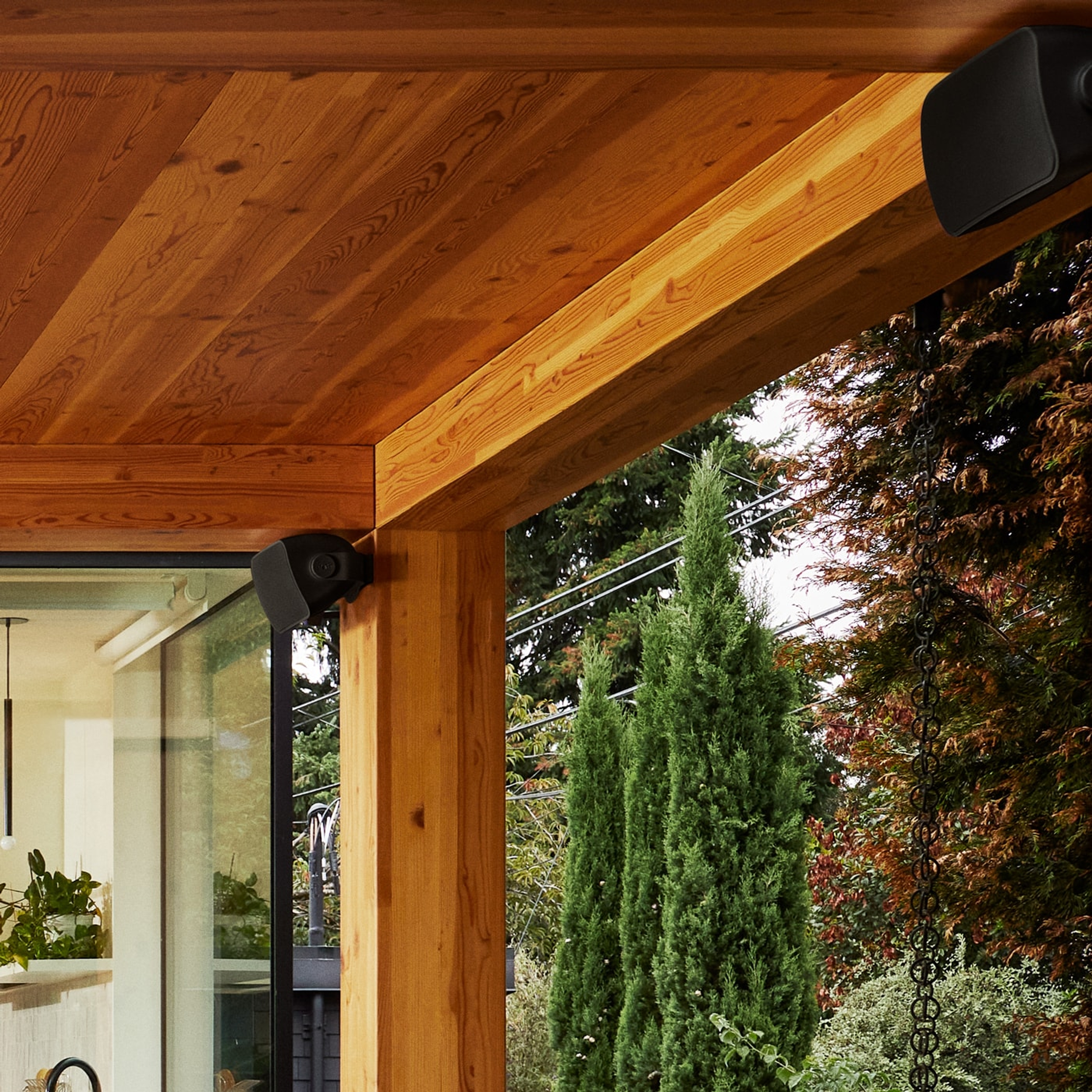 Closeup of outdoor speakers by Sonos and Sonance installed in the eaves of a patio