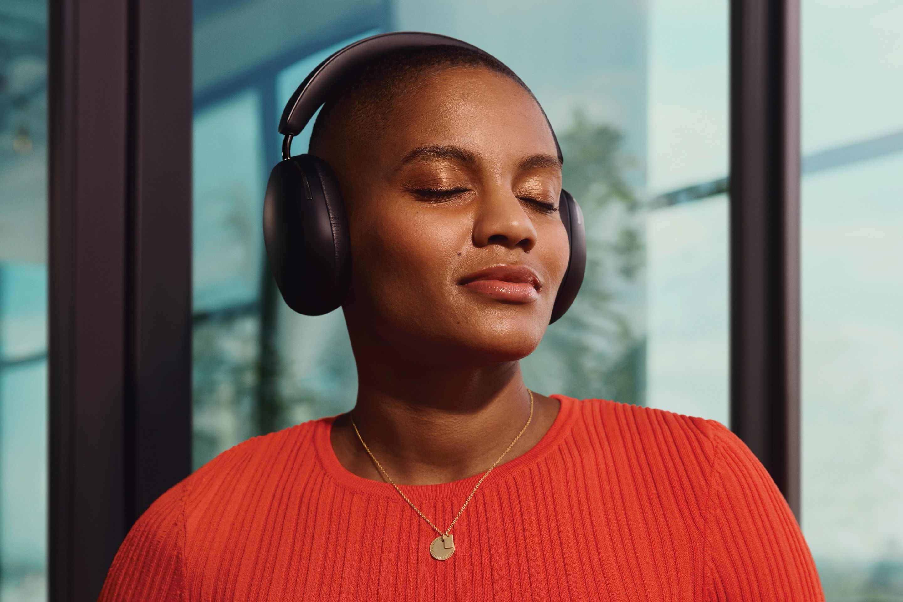 Person listening to music on black Sonos Ace headphones with eyes closed