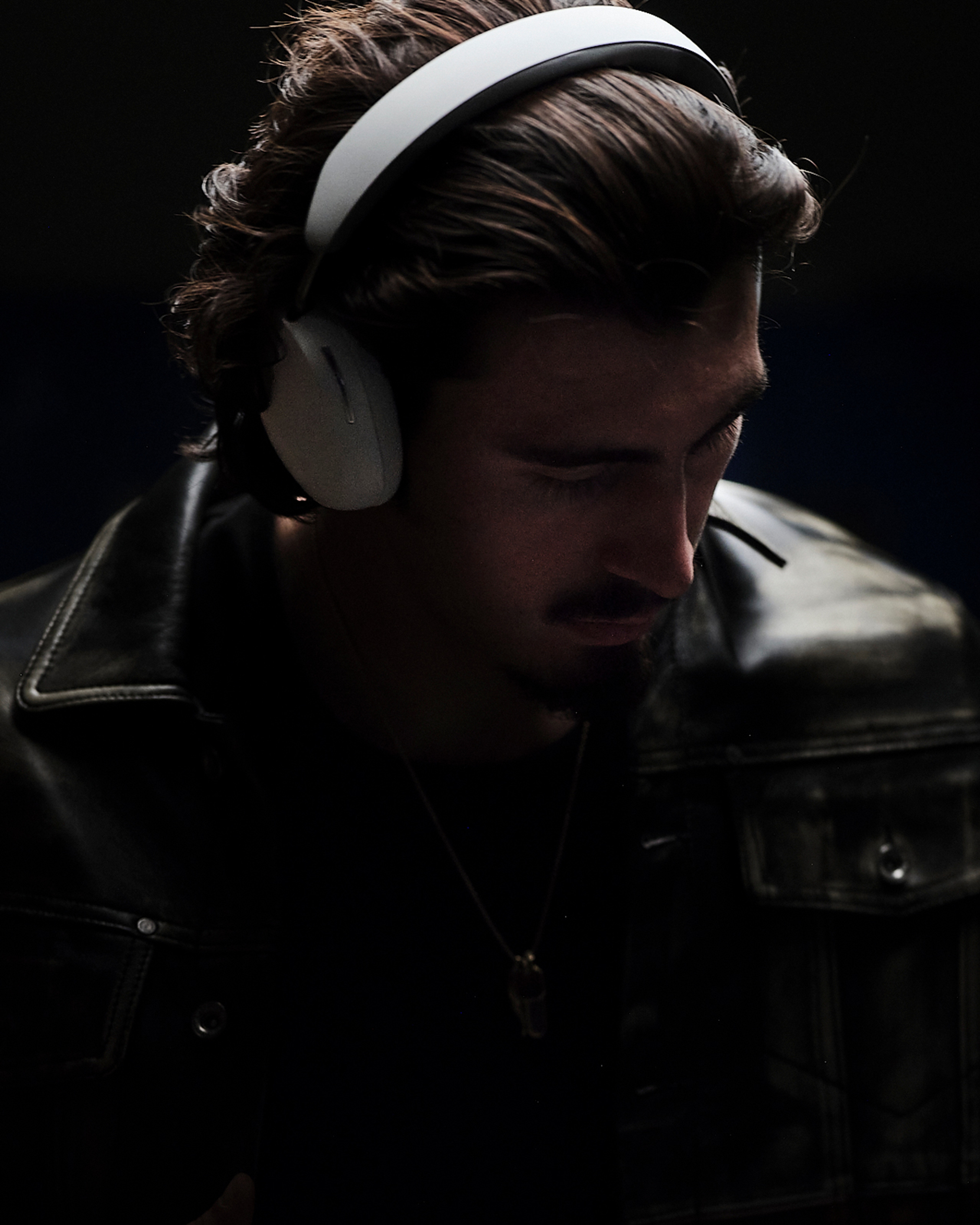 Una persona lleva puesto un par de audífonos Sonos Ace en color blanco sobre un fondo negro