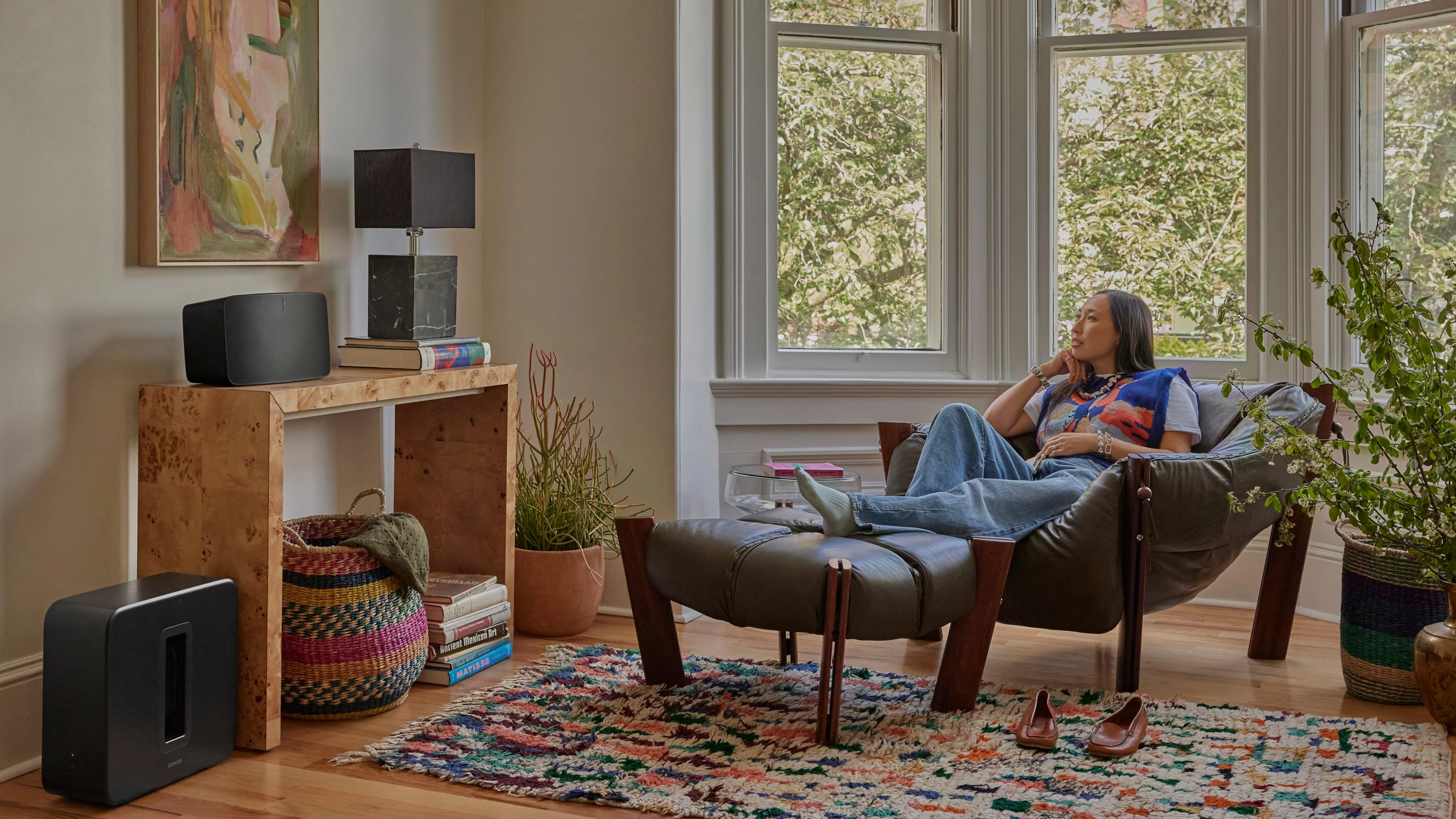 Person listening to Sonos Five and Sub 4 on a lounge chair