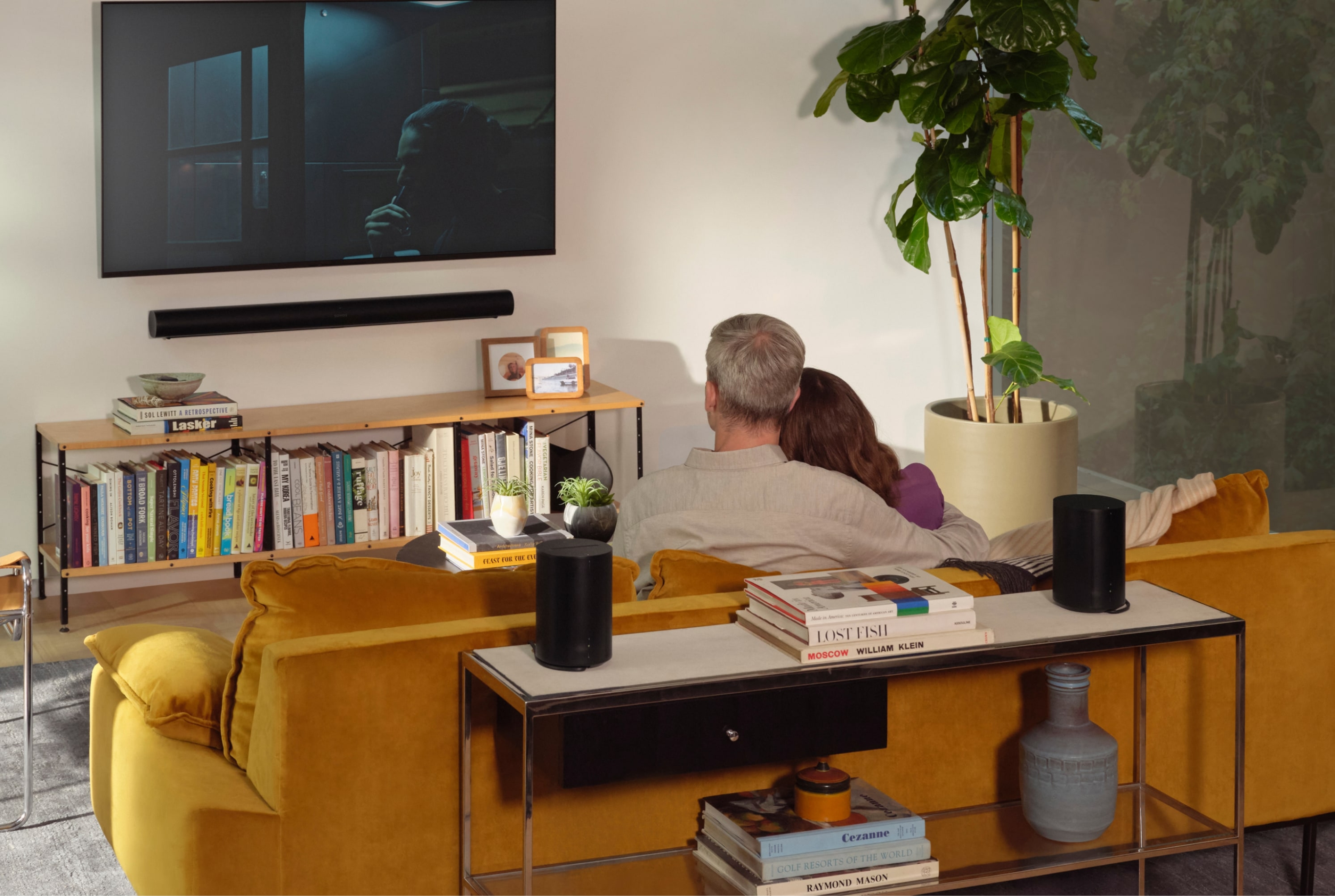 Sonos Arc and Era 100 surround set in a living room with a couple