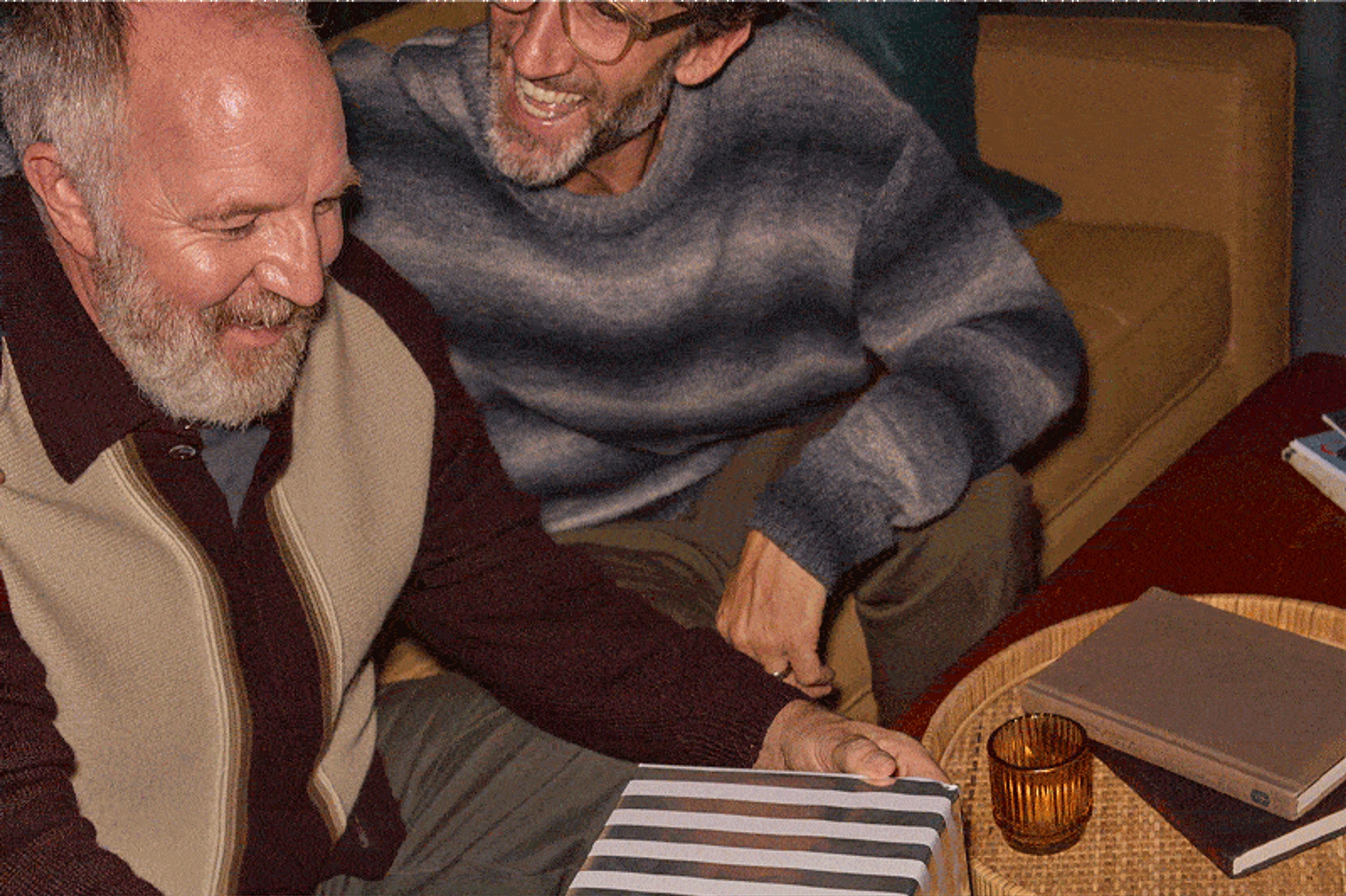 A dad unwrapping a holiday gift of Sonos Move 2 from his son