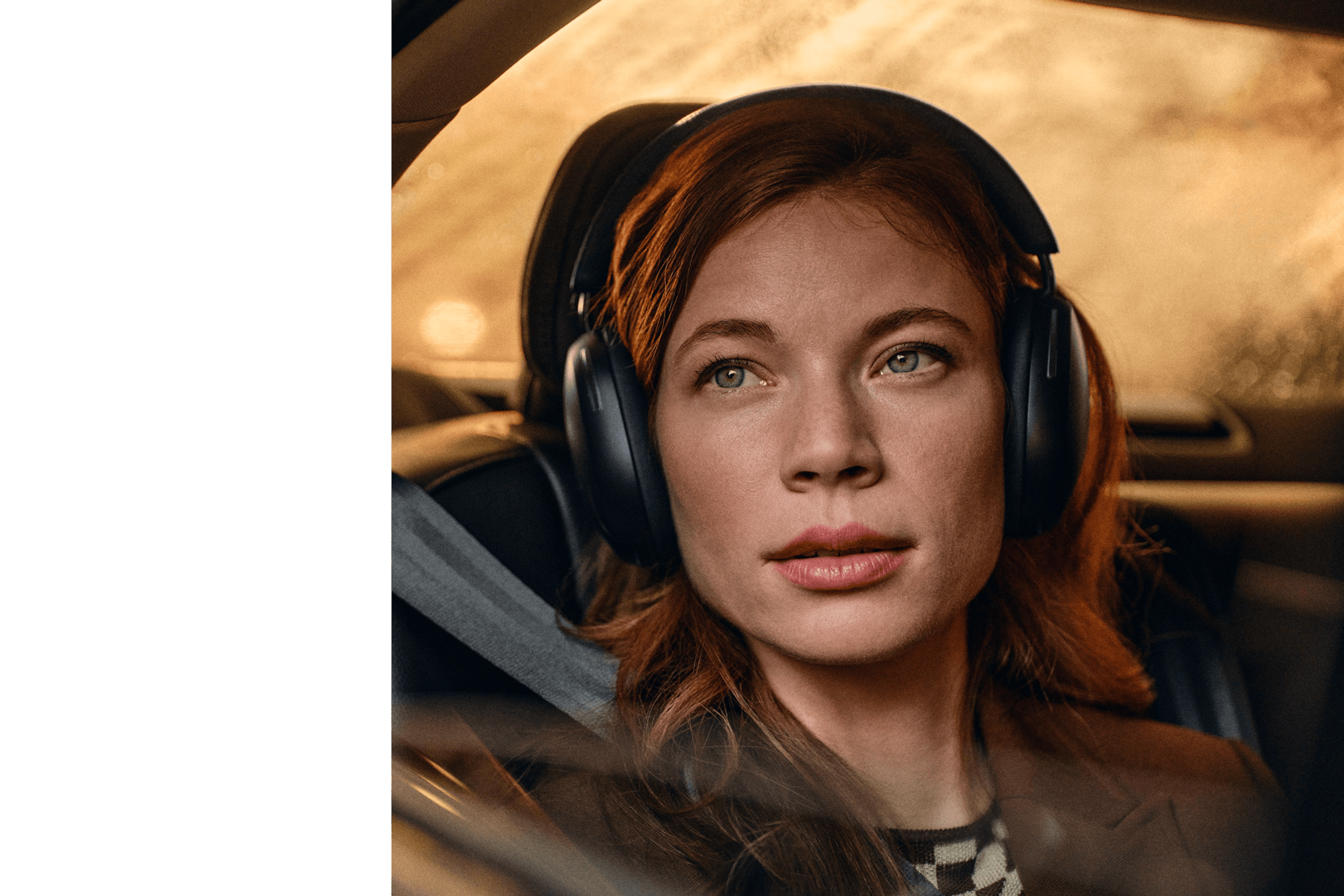Kvinne som har på et par svarte Sonos Ace-hodetelefoner mens hun sitter i en bil