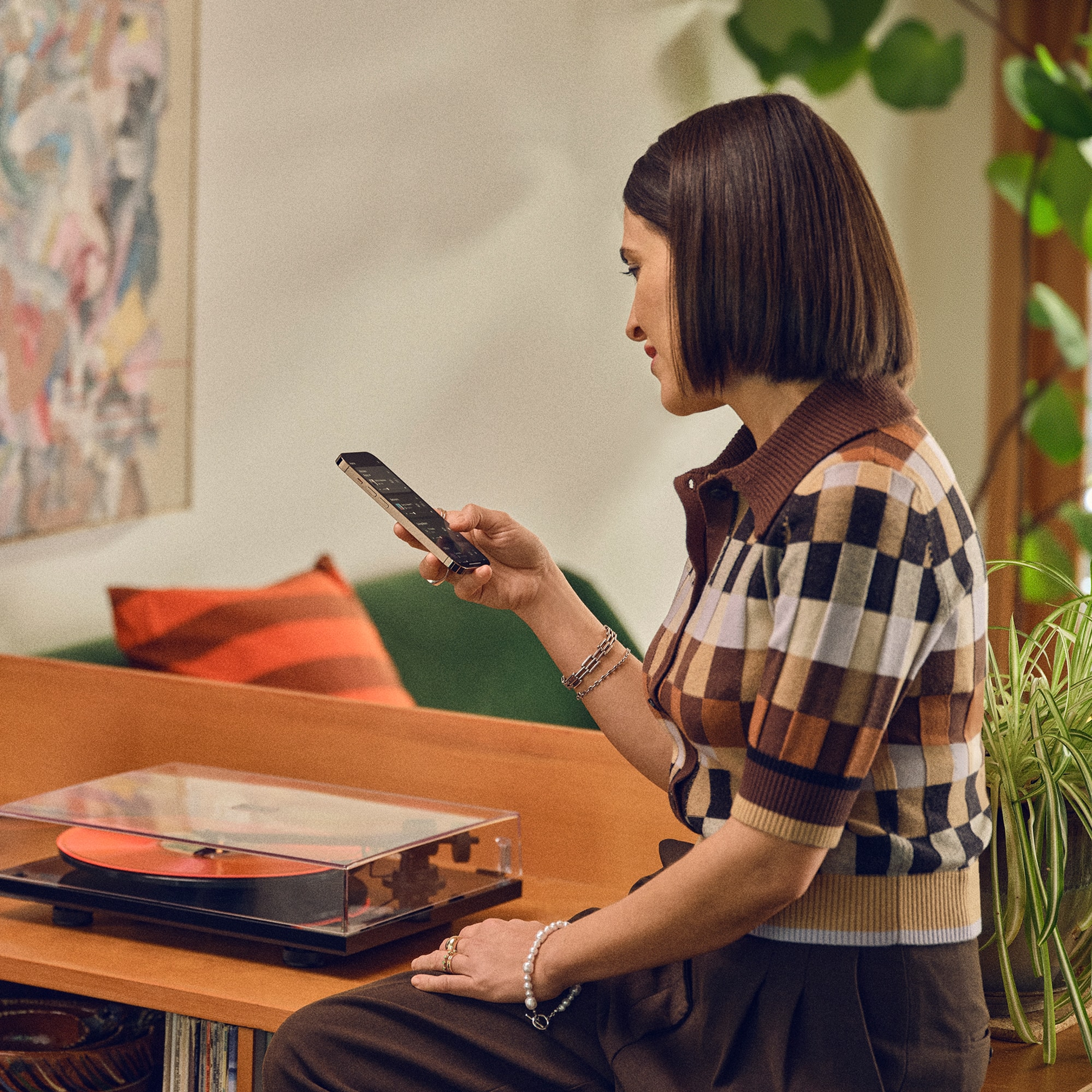 Una mujer usa la app Sonos en su teléfono