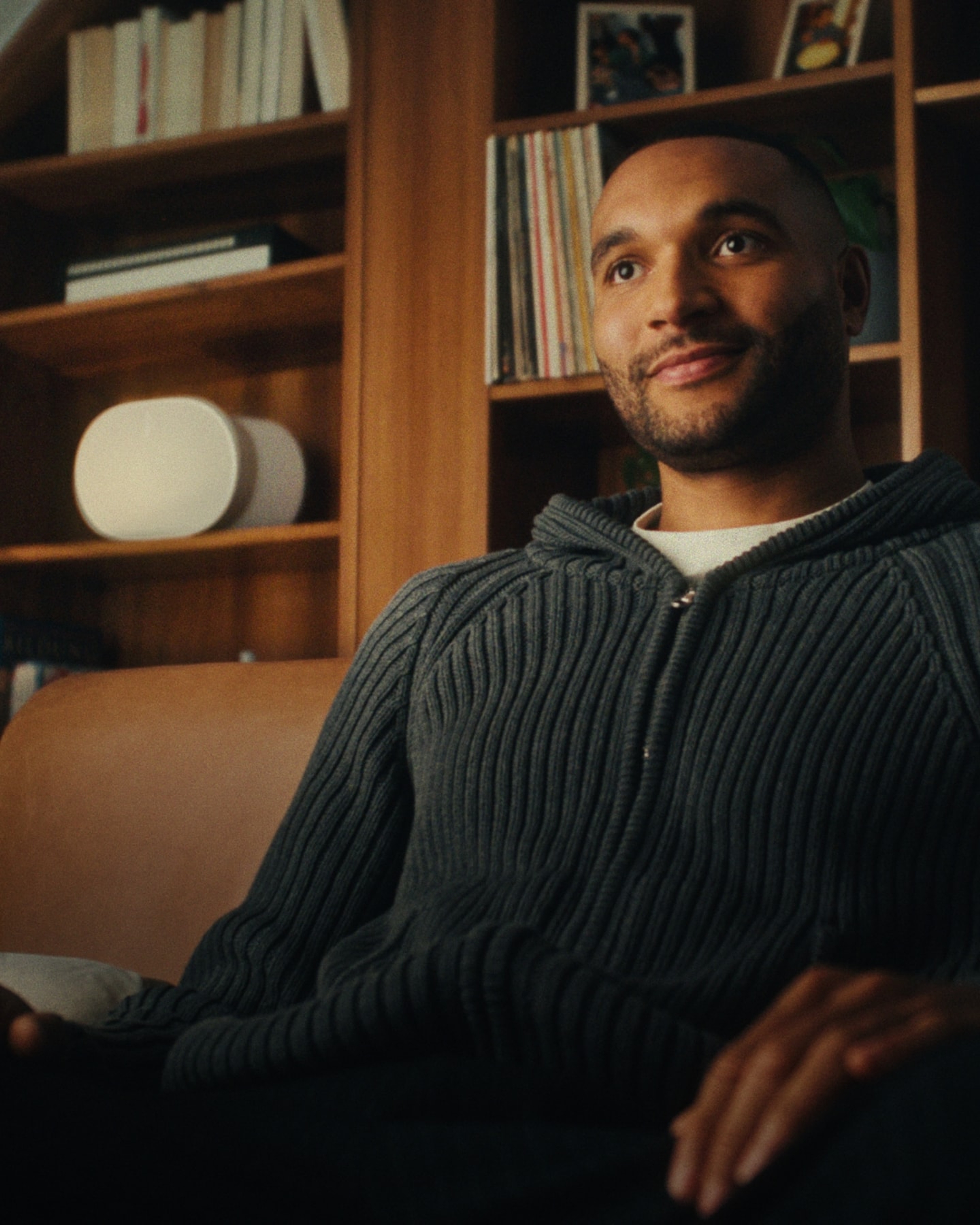 German footballer Jonathan Tah listening to a pair of white Sonos Era 300 speakers in his home